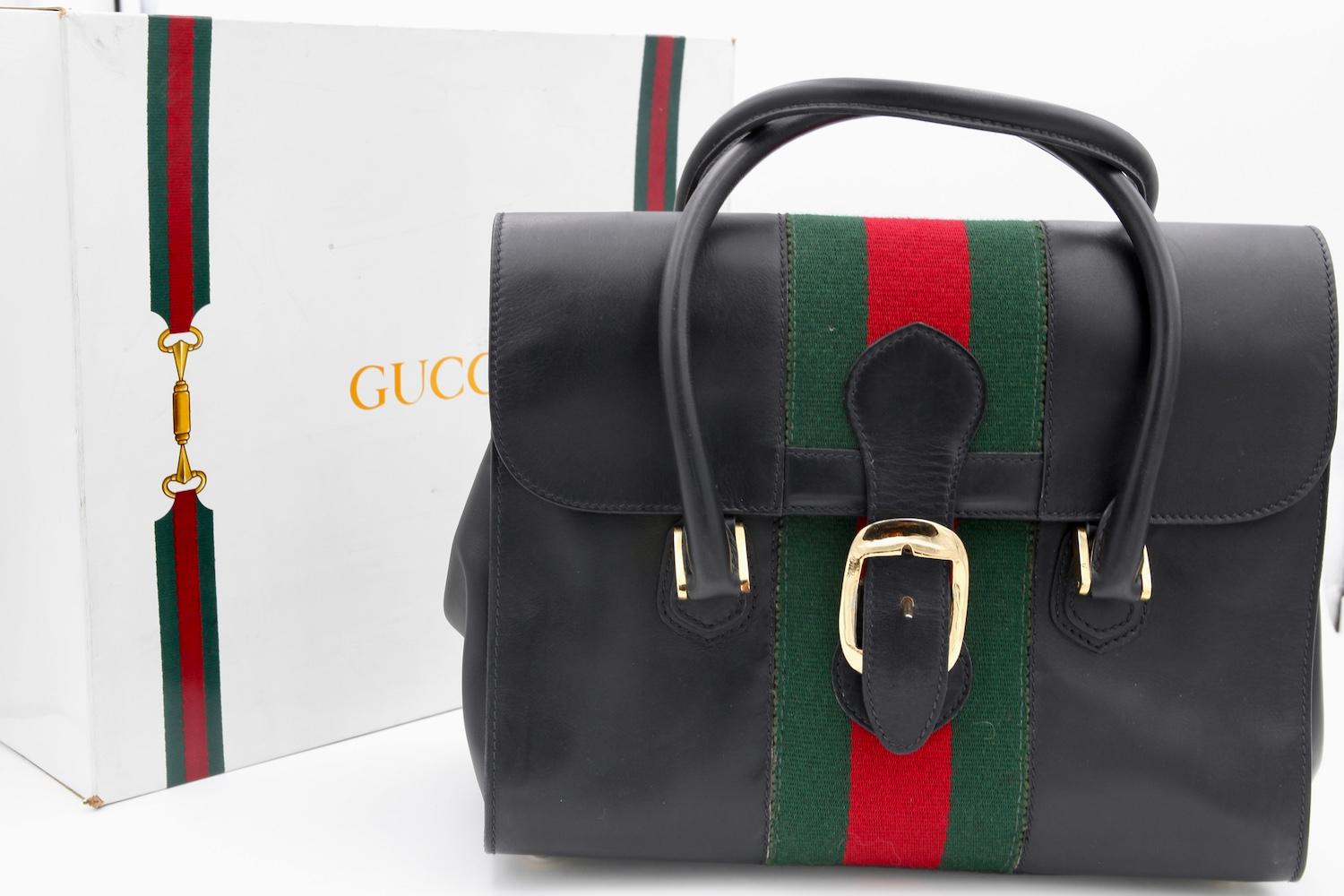 Vintage GUCCI Black Leather Doctor Bag, c.1980s.
Vintage Black Gucci Doctor Bag with classic green and red stripe accent through the center.
Featuring Gold hardware and buckle closure with gold feet on the base of bag. 
Double handle with 5inch