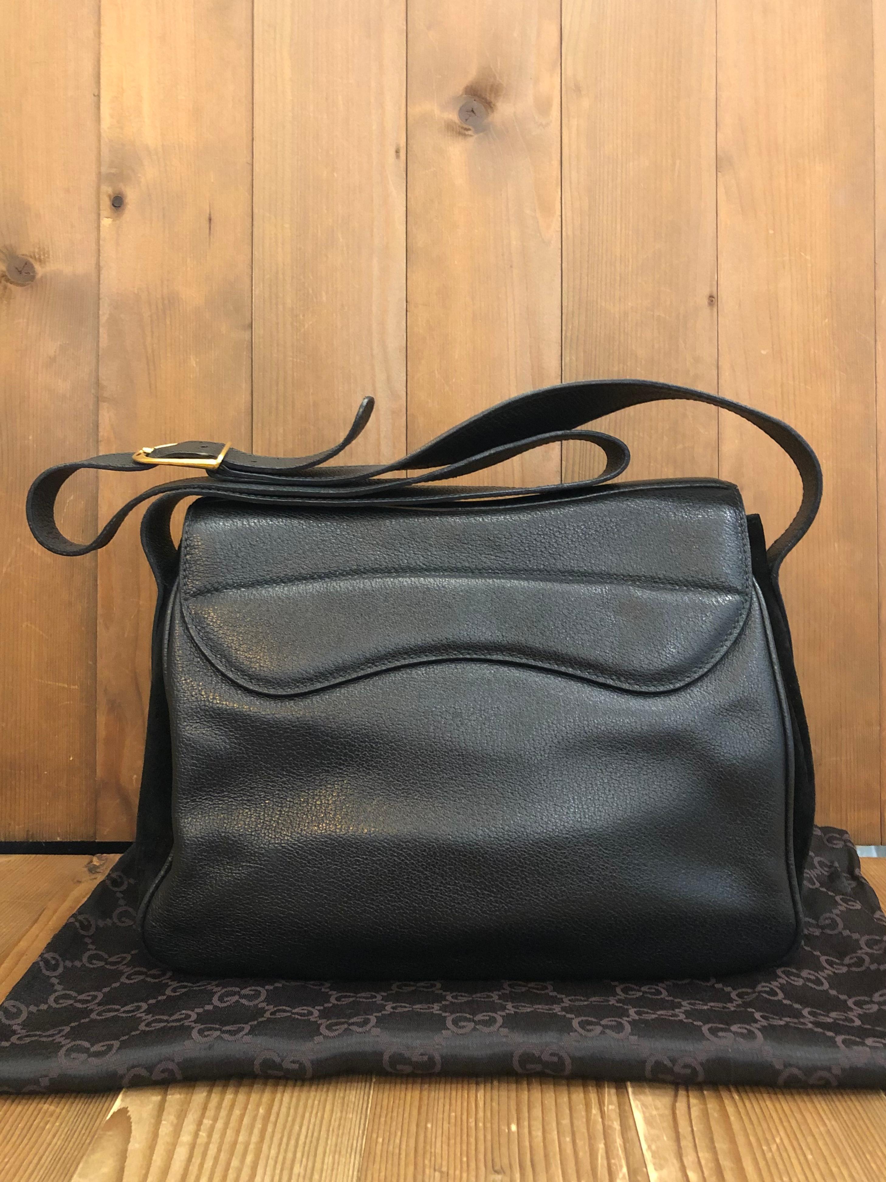 This vintage GUCCI saddle camera bag is crafted of pigskins and nubuck leather in black featuring matte gold toned hardware. Front flap double magnetic snap closure opens to a black diamanté jacquard interior featuring three compartments with a
