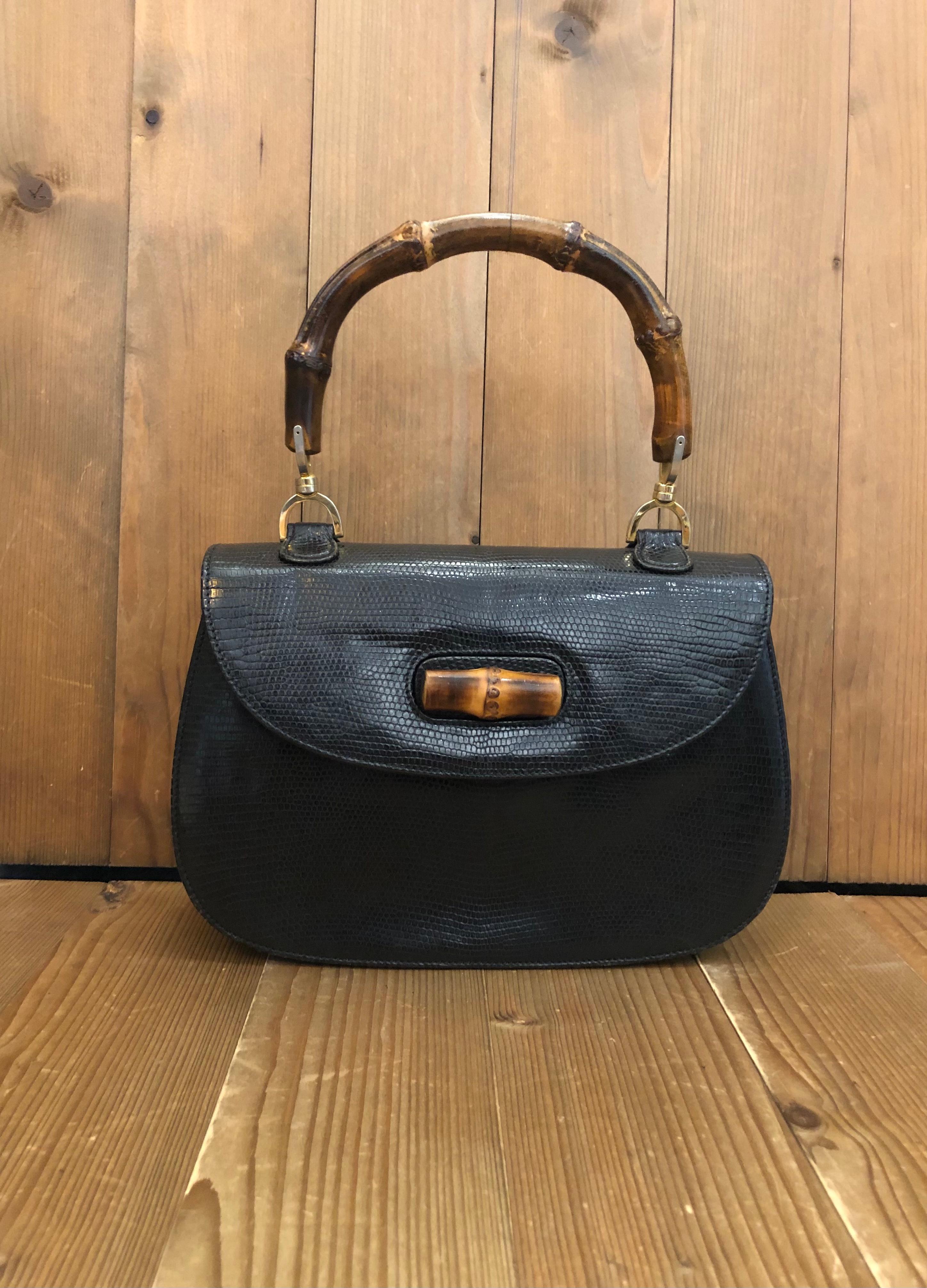 Diese Bambus-Handtasche im Vintage-Stil von GUCCI ist aus exotischem Leder in Schwarz gefertigt und verfügt über goldfarbene Beschläge und einen charakteristischen Gucci-Bambusgriff. Der Bambus-Drehverschluss auf der Vorderseite öffnet sich zu einem