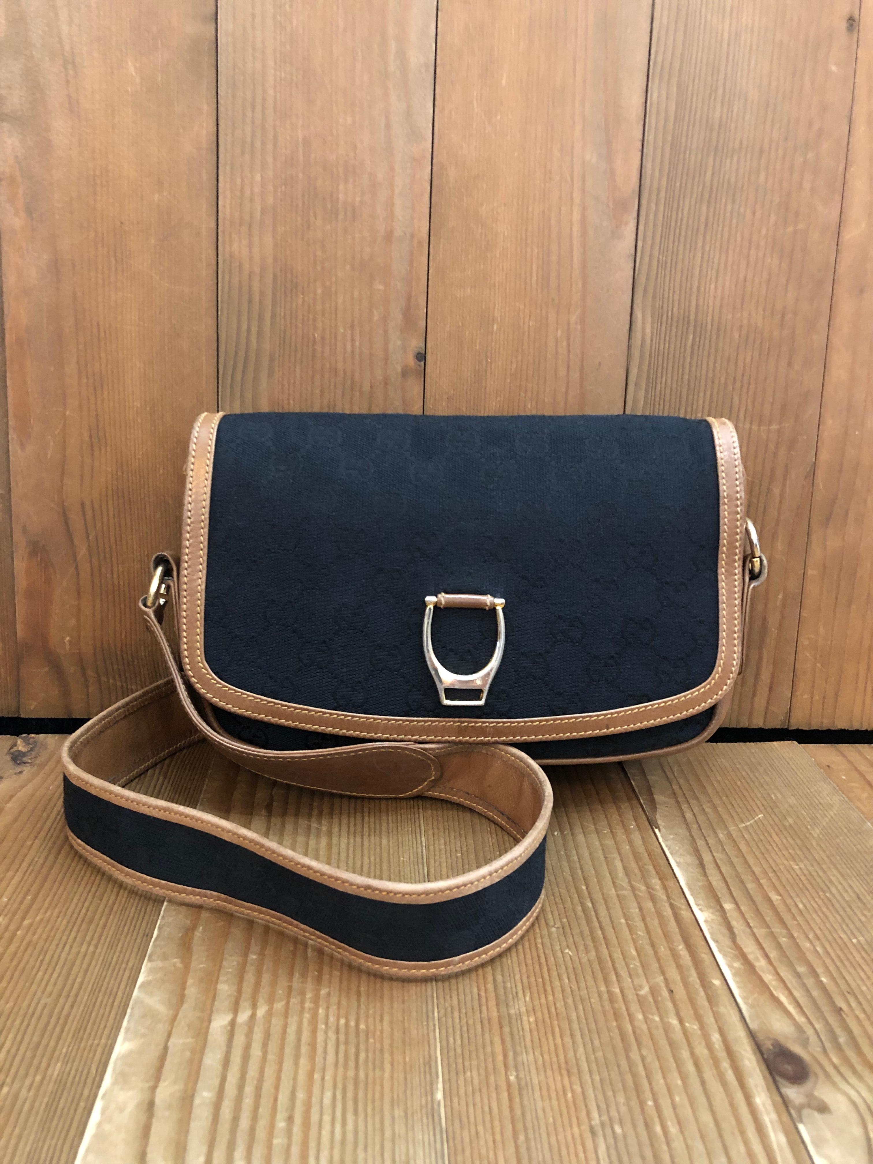 This Vintage GUCCI Boutique shoulder bag is crafted of GG jacquard in black trimmed with brown smooth leather. Front flap snap closure opens to a black leather interior featuring a patch pocket and a zippered pocket. Made in Italy. Measures