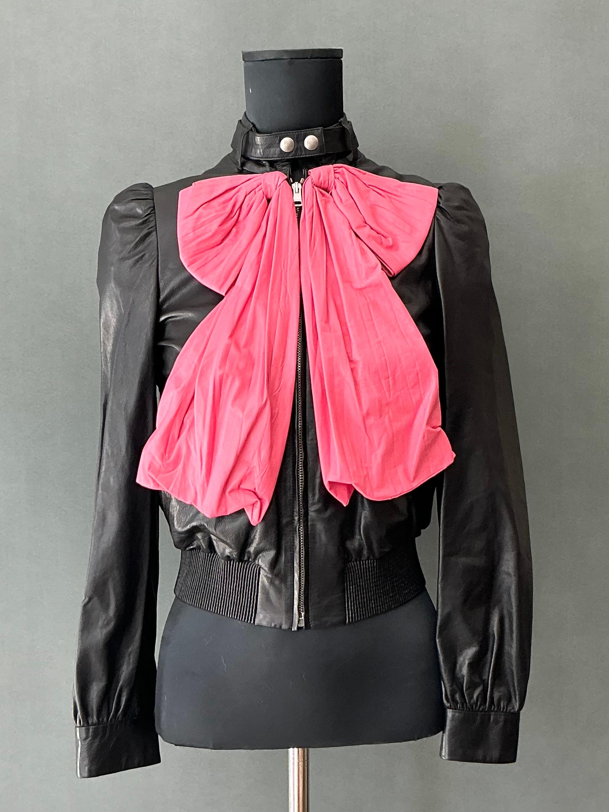 This Vintage Gucci Bow Accent Leather Biker Jacket is a unique blend of classic biker chic and luxurious design, showcasing the iconic craftsmanship of Gucci with a playful, feminine twist. Featuring a bold leather design and an unexpected bow