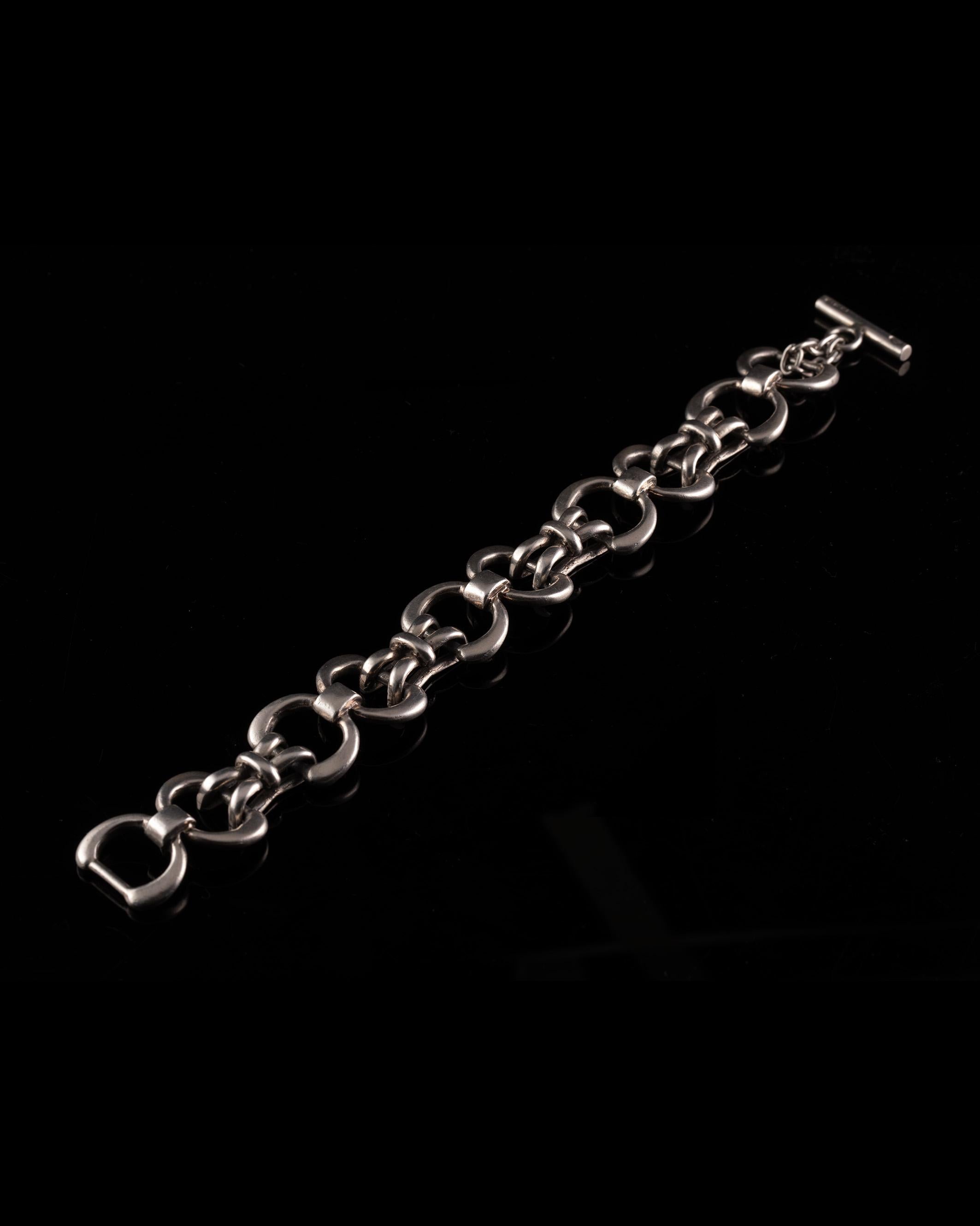 Step back to the 70s with the vintage Gucci bracelet. Made of silver and featuring stylized motifs, it embodies the era's creativity and sophistication. This timeless piece is a conversation starter, symbolizing individuality and an appreciation for