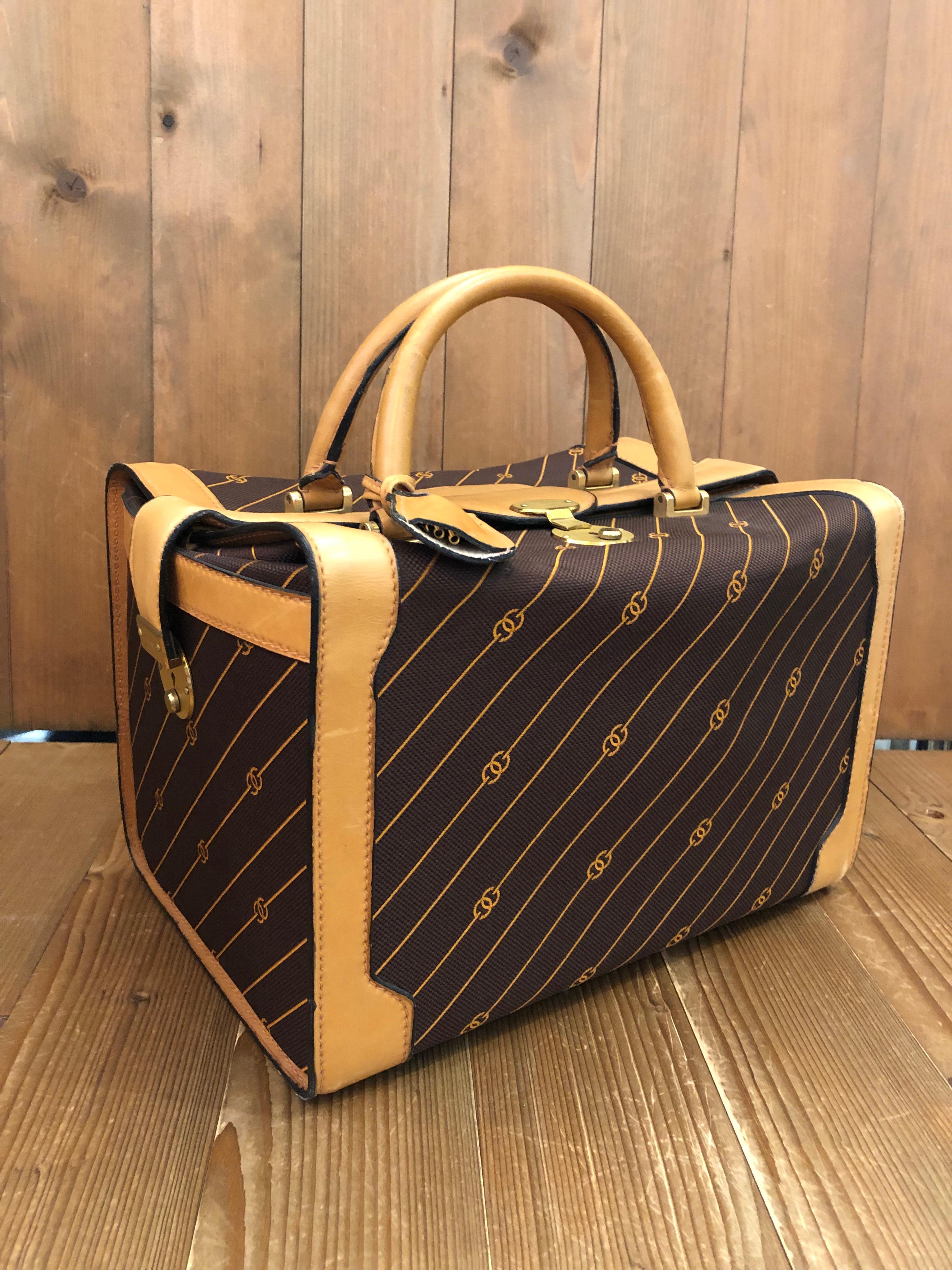 This 1970s vintage GUCCI soft-sided vanity trunk is crafted of interlocking GG jacquard in brown trimmed with beige smooth leather. This vanity bag features three locks with one on top and one on the each side. Top closure opens to a beige interior
