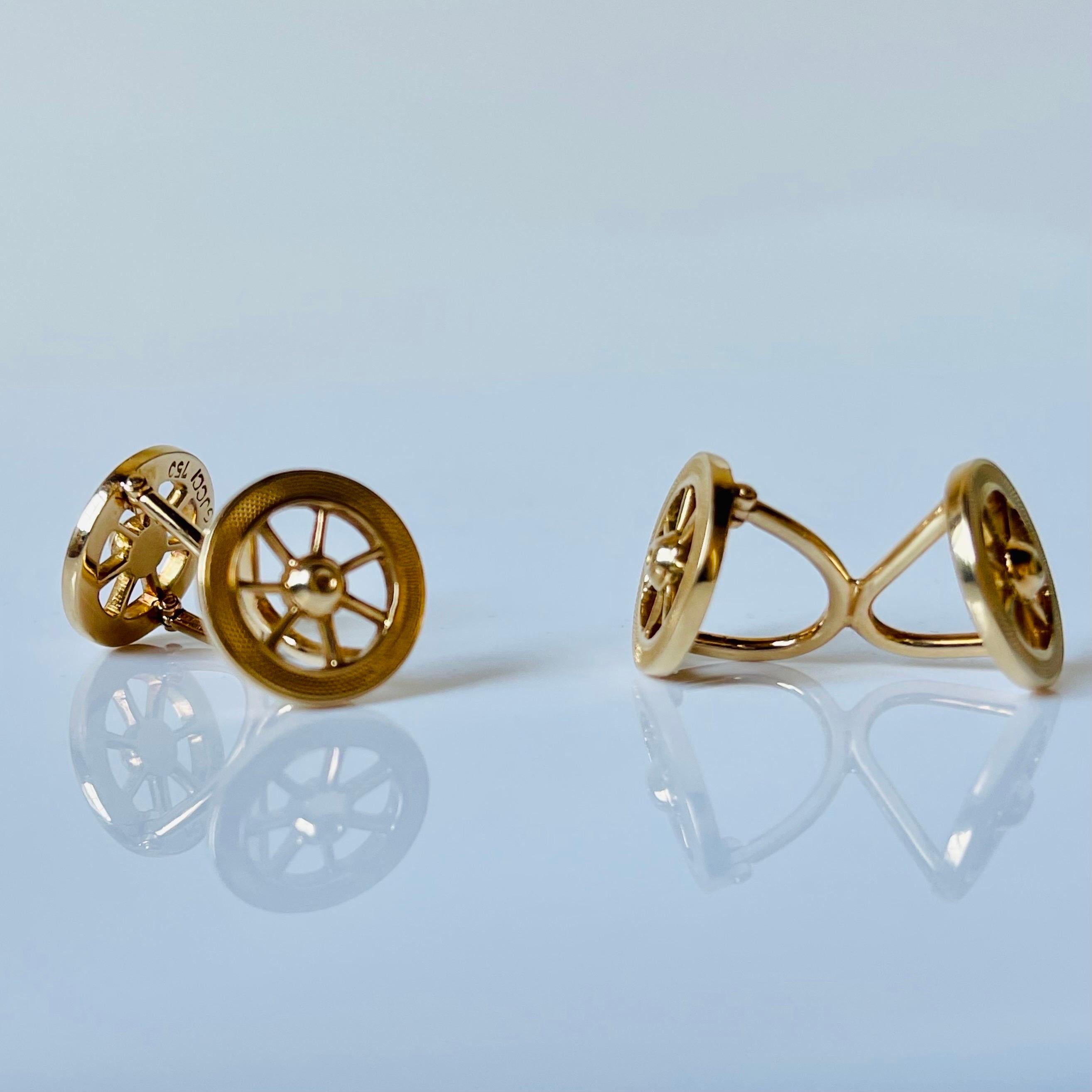 An elegant pair of vintage gold car wheel cufflinks, signed Gucci, mounted in 18K gold, stamped 750, Italy, circa 1980. Two-sided finely engraved car wheel design featuring a movable wheel for easy entry into a shirt or jacket, in an excellent