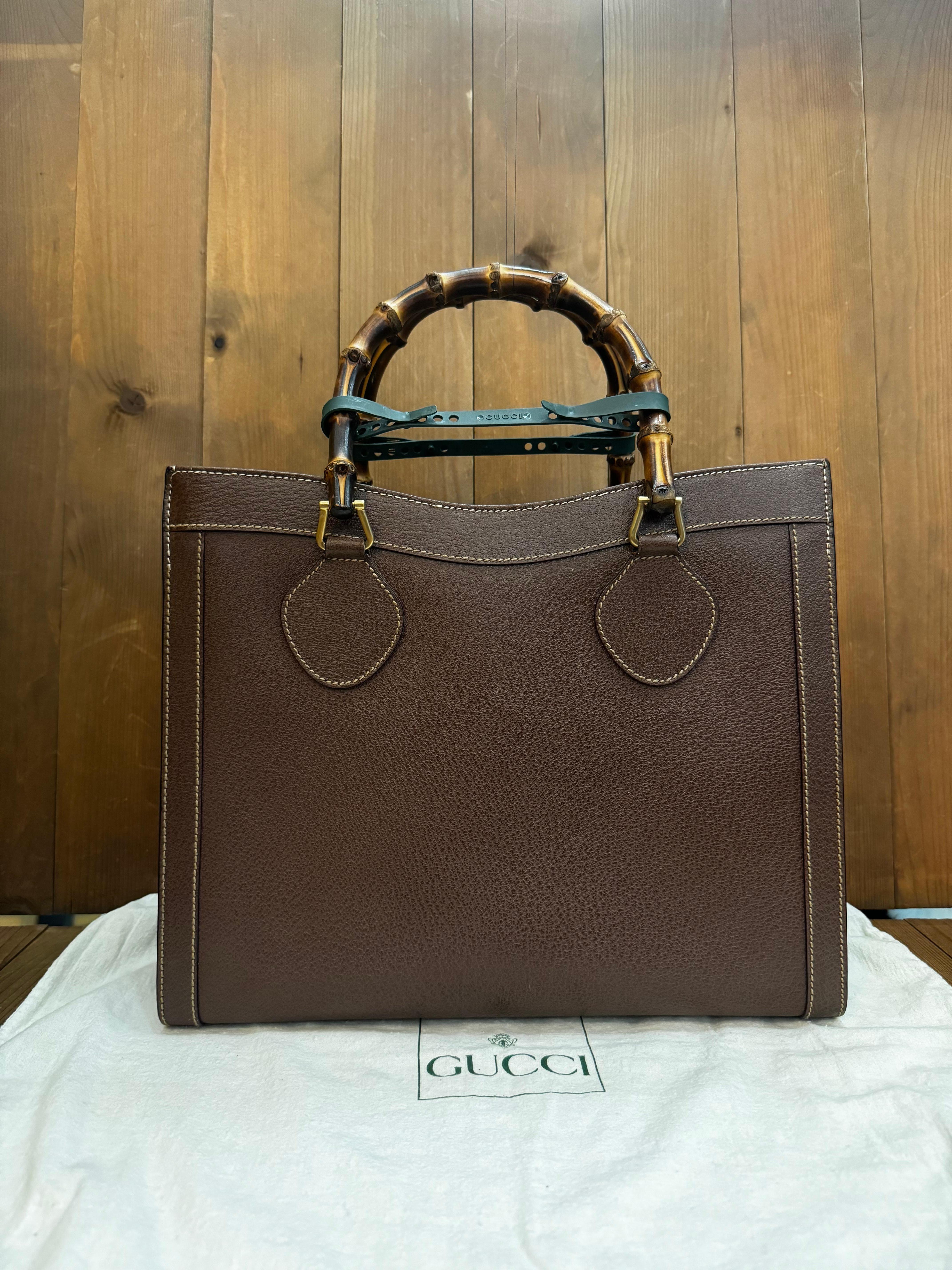 This vintage GUCCI Diana bamboo tote is crafted of pigskin leather in brown featuring brushed gold toned hardware and bamboo handles. Top magnetic snap closure opens to a new interior in beige featuring two main compartments/one zip compartment with