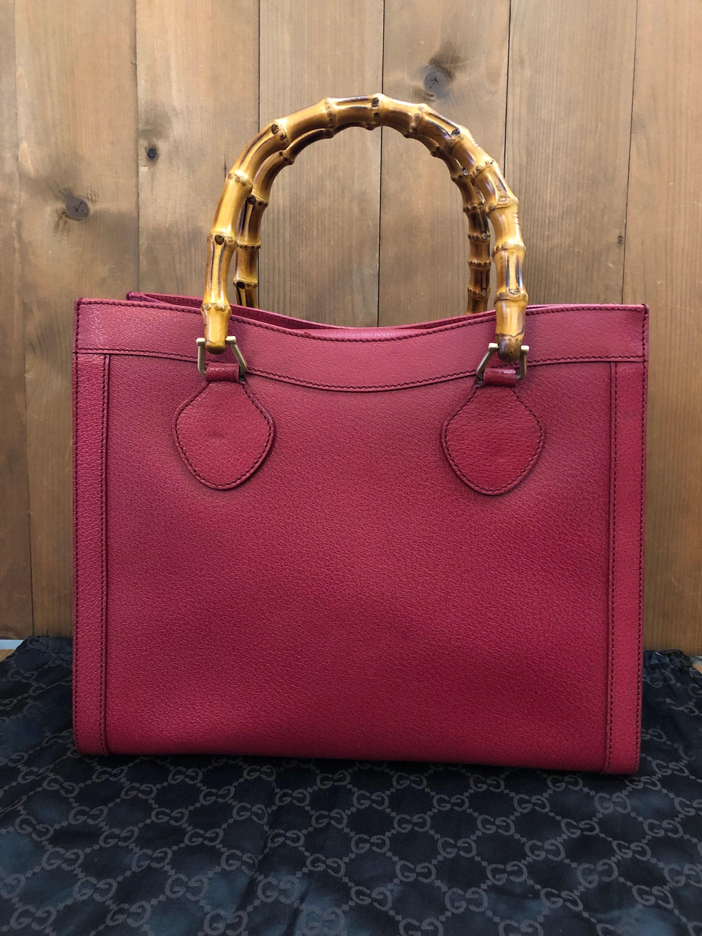 This vintage GUCCI Diana bamboo tote is crafted of pigskin’s leather in dark pink/red and brushed gold toned hardware. Top magnetic snap closure opens to Gucci’s iconic diamanté jacquard interior featuring two main compartments/one zippered