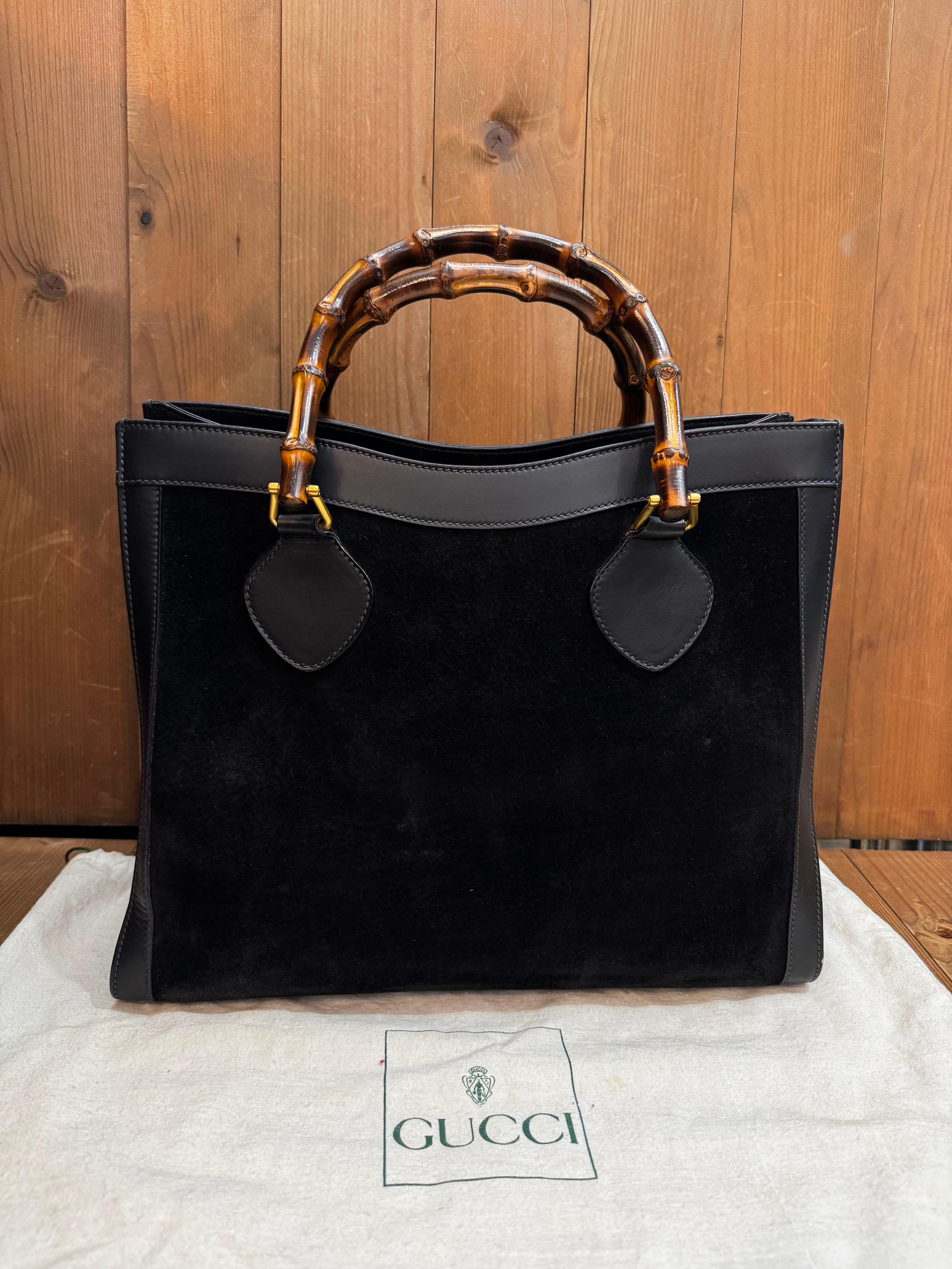 This vintage single-compartment GUCCI Diana bamboo tote is crafted of nubuck and smooth calfskin leather in black featuring matt gold toned hardware and bamboo handles. Wide top opens to a black nubuck leather interior featuring a zippered pocket.