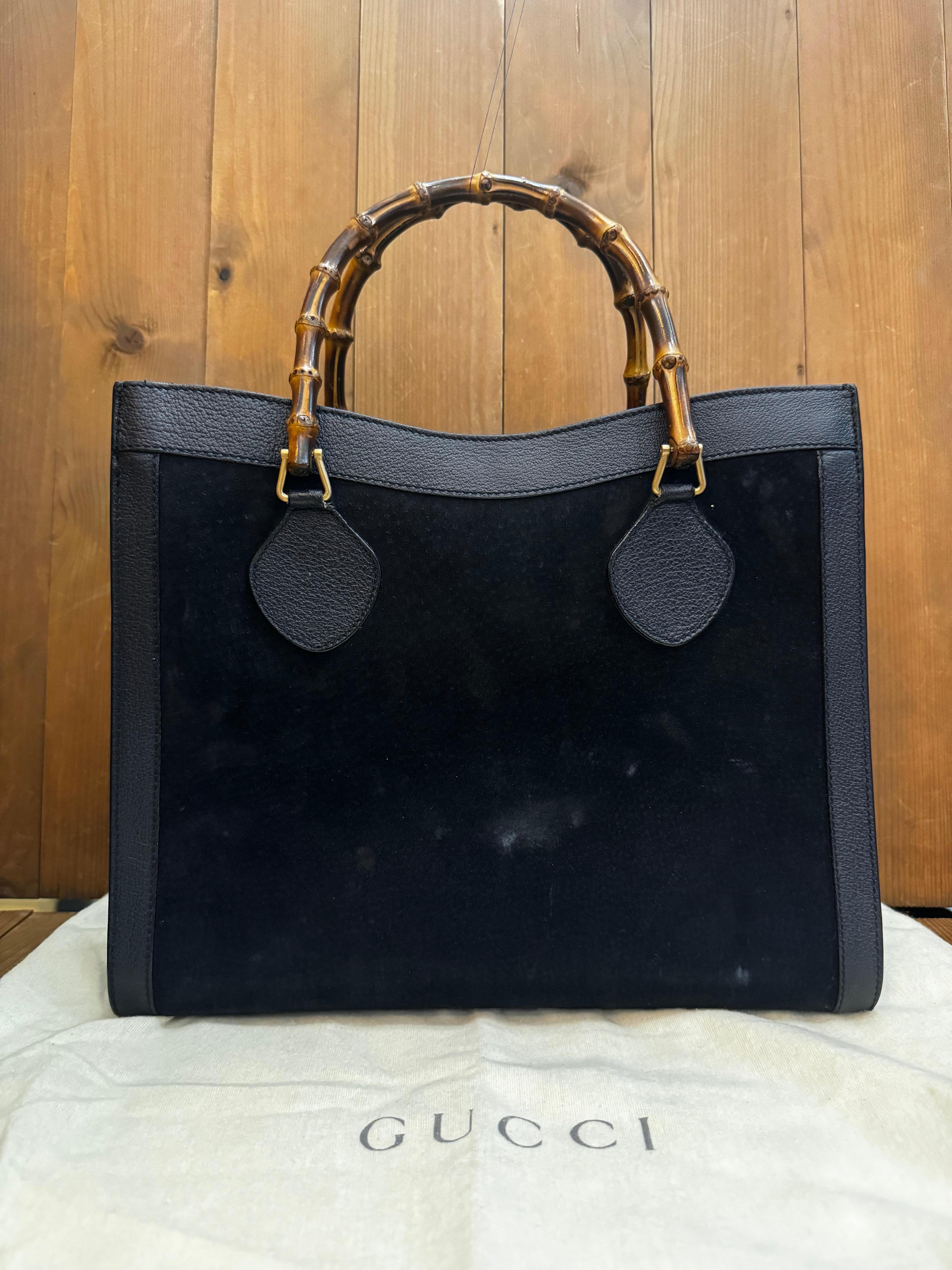 This vintage GUCCI Diana bamboo tote is crafted of pigskin leather and nubuck in navy featuring matt gold toned hardware and bamboo handles. Top magnetic snap closure opens to a new interior in black featuring two main compartments with one zippered