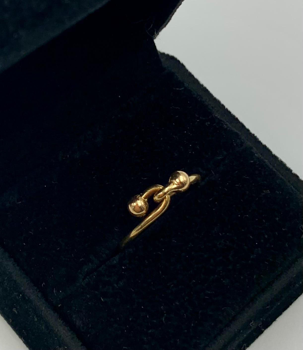 Anello Gucci Estate in oro giallo 18 carati con doppio gancio che simboleggia amore, impegno e unione.
20° secolo
Il motivo del doppio gancio rappresenta il legame tra due persone che si impegnano reciprocamente. Gli anelli intrecciati significano