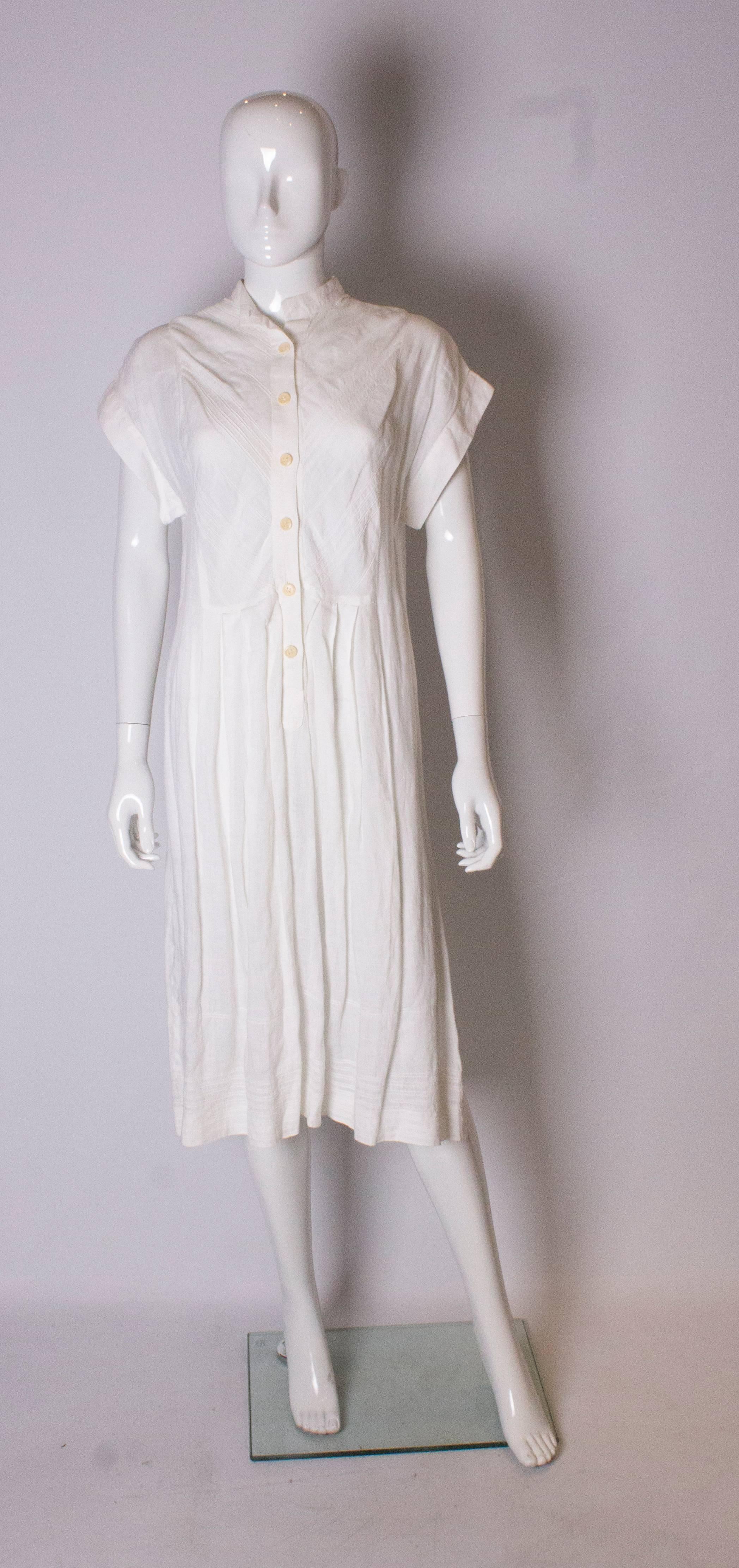 A great linen dress for Summer by Gucci.  The dress has a stand up collar with cap sleeves, button opening at the front and attractive stitch detail at the front and hem  