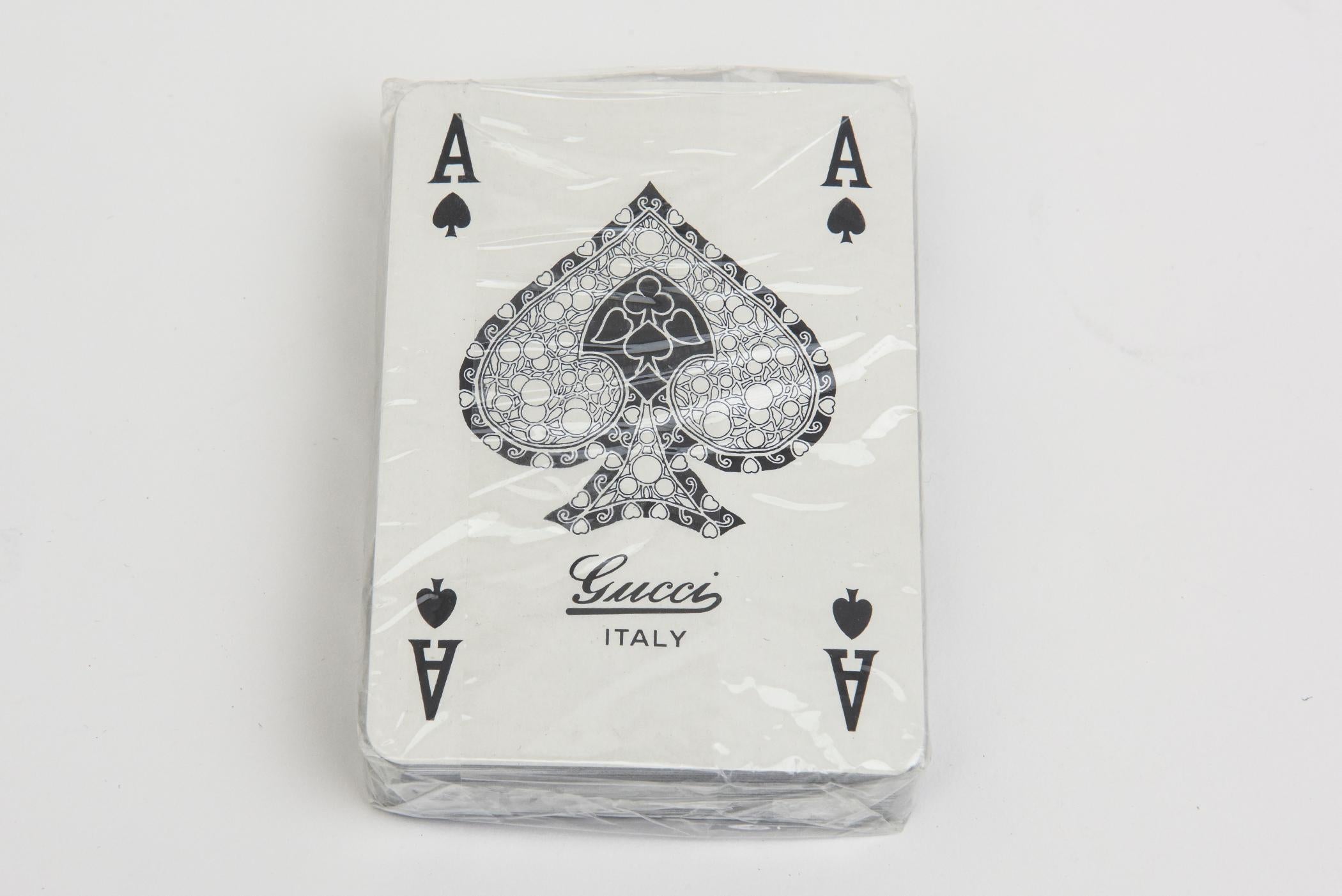 Ce jeu de cartes à jouer Gucci, jamais utilisé, est vintage et italien, datant des années 1970. Il s'agit de deux jeux, l'un en blanc et l'autre en noir pour le dos. L'un était déballé comme nous l'avons acheté et l'autre est encore sous cellophane.