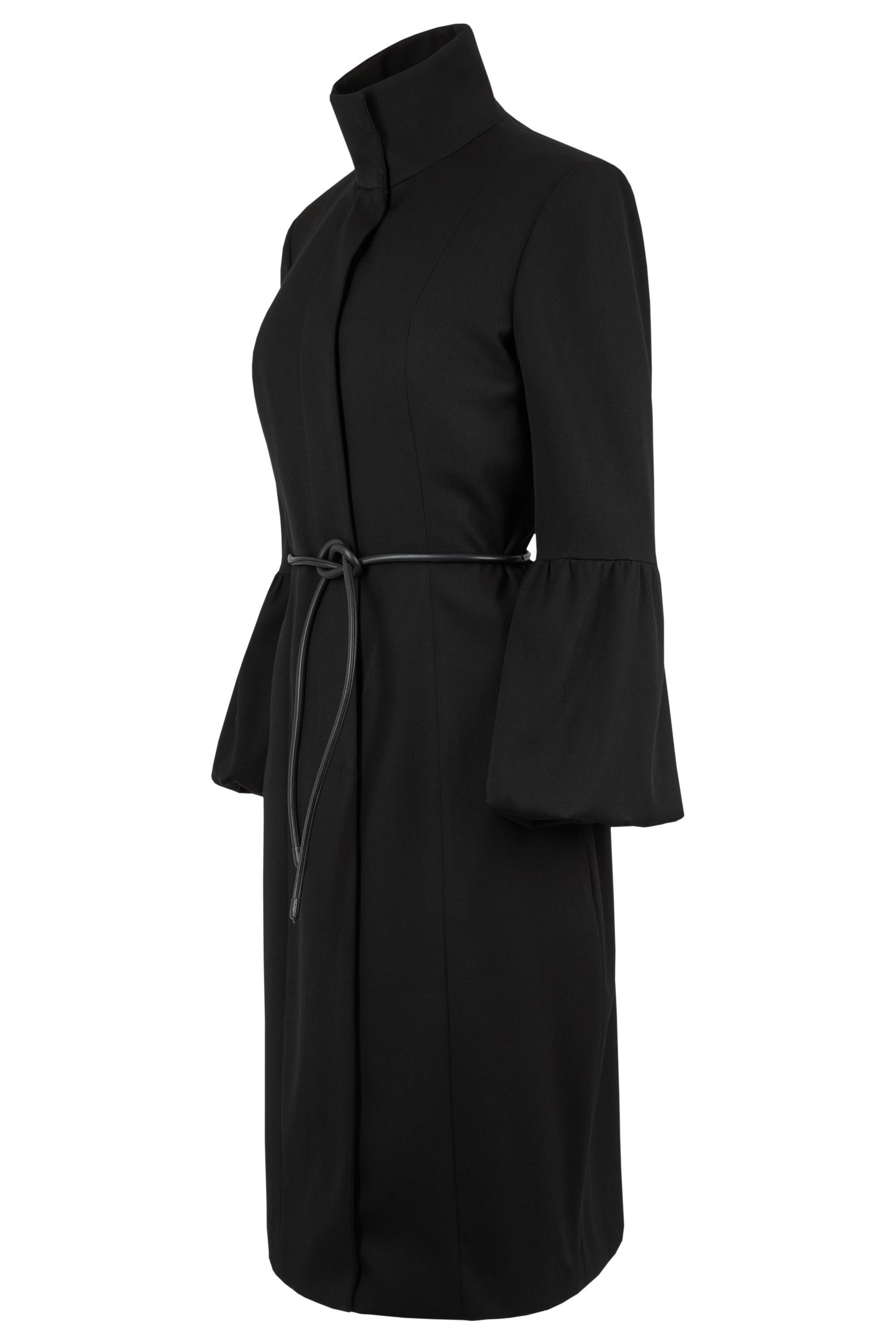 Vintage Gucci Herbst/Winter 1999 Mantel von Tom Ford . Minimalistische Silhouette, dramatischer hoher Kragen, geriffelte Ärmel und ein schmaler Lederkordelgürtel, der die Taille einschnürt. Wird mit einem Knopfverschluss vorne geschlossen. 

Wie auf