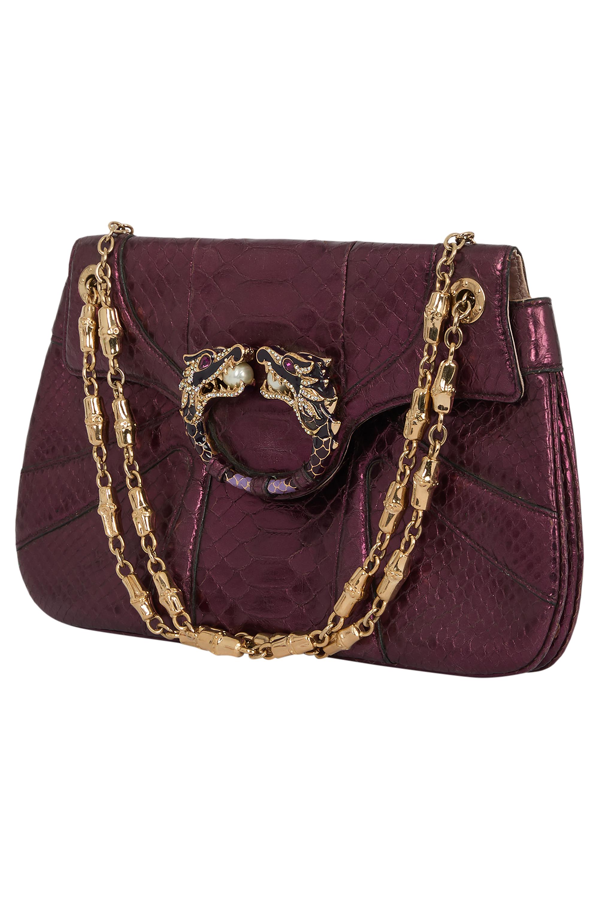 Pochette violette Gucci by Tom Ford Fall Winter 2004. Il est orné d'un dragon au centre perlé, d'un corps en serpent violet irisé, d'une doublure en satin lilas, d'une chaîne d'épaule dorée et d'une poche intérieure au dos.

Objet vintage en très