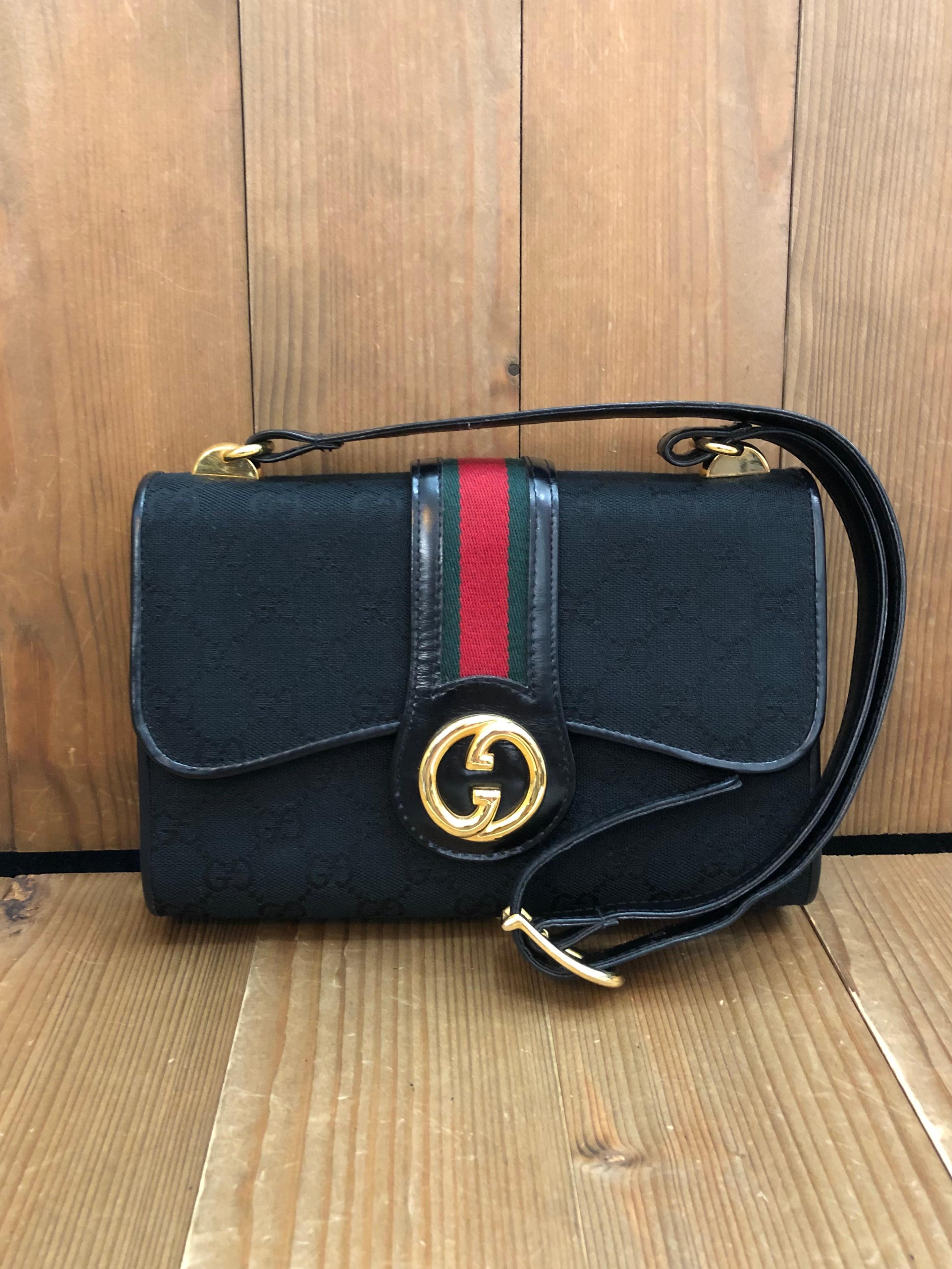 This Vintage GUCCI Web shoulder bag is crafted of GG monogram jacquard in black and black smooth leather featuring Gucci’s iconic red/green stripe along the top to the front. Front flap snap closure opens to a black leather interior featuring a
