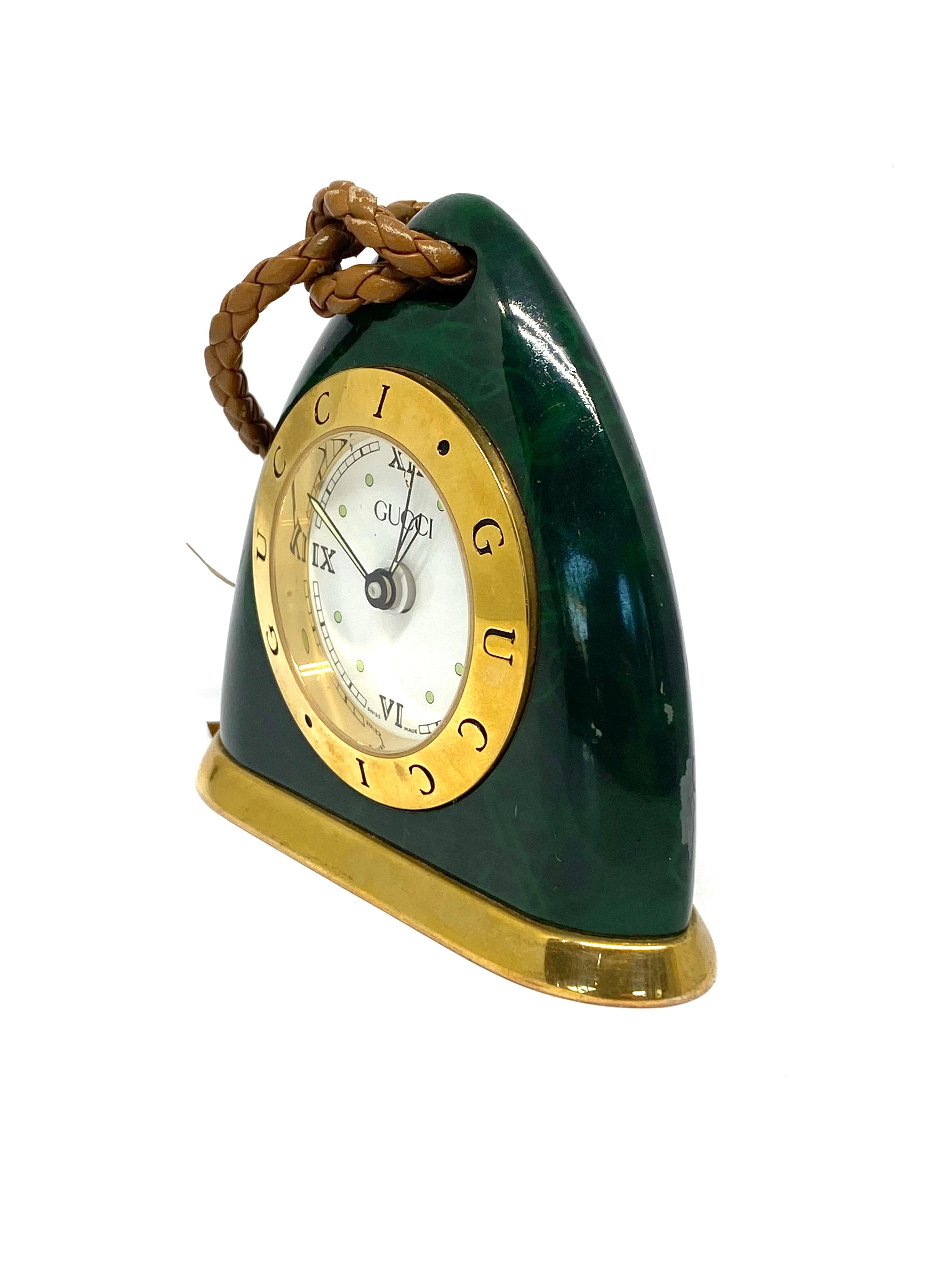 Product details:

Circa 1970.
Featuring green finish, gold vermeil and brown leather stirrup, alarm detail on the back. The clock is swiss made.
Signed Gucci and numbered 007279.
Total weight is 503.8 grams.
The clock comes with green Gucci original