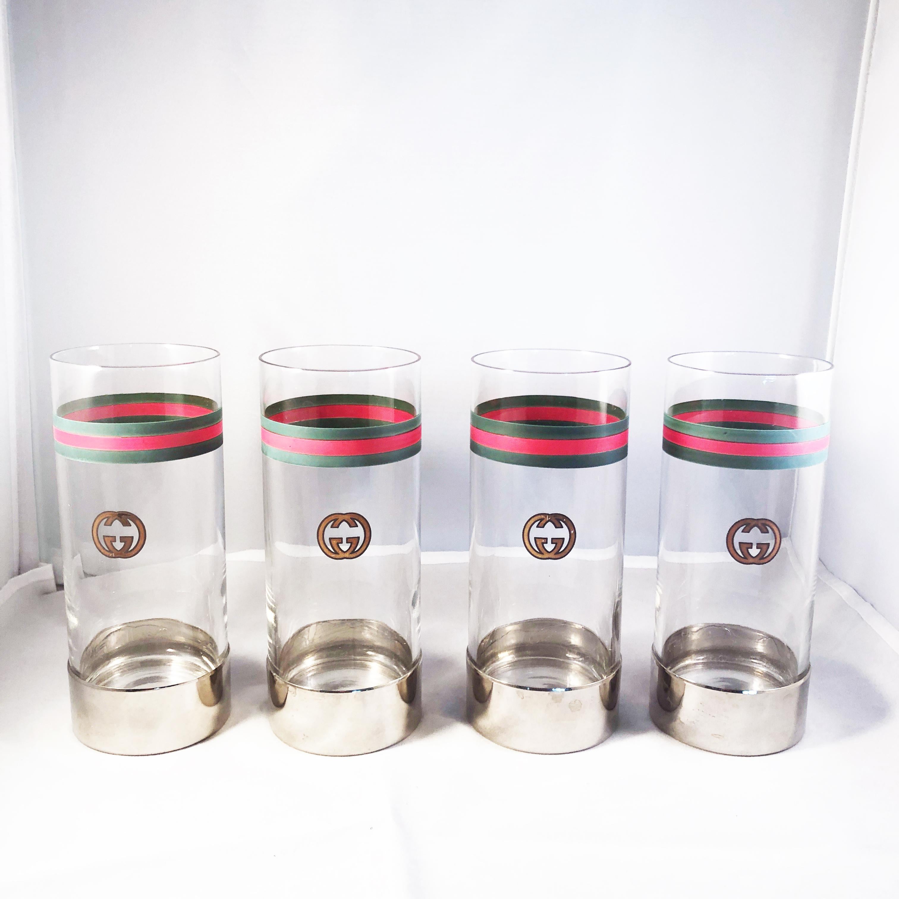 Celebrate in style with this set of 4 rare vintage highball glasses by Gucci, likely made in the late 70s.  Each glass is painted with Gucci's signature web and GG logo with a silver metal base.  Preowned/vintage with some signs of use & wear: some