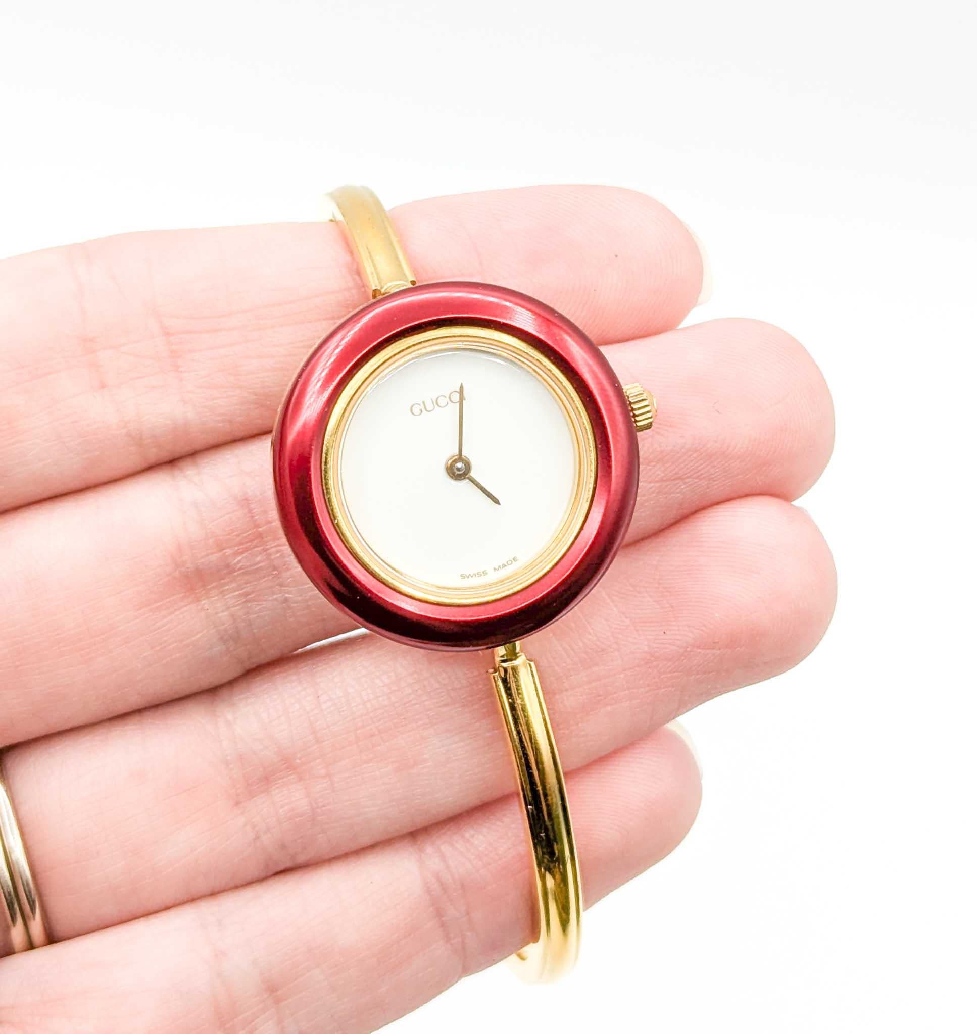Diese authentische Gucci-Armbanduhr im Vintage-Stil bietet zeitloses italienisches Design und verspielte Vielseitigkeit. Die aus Edelstahl gefertigte Uhr mit goldfarbener Beschichtung misst 26 mm im Durchmesser und verfügt über ein minimalistisches
