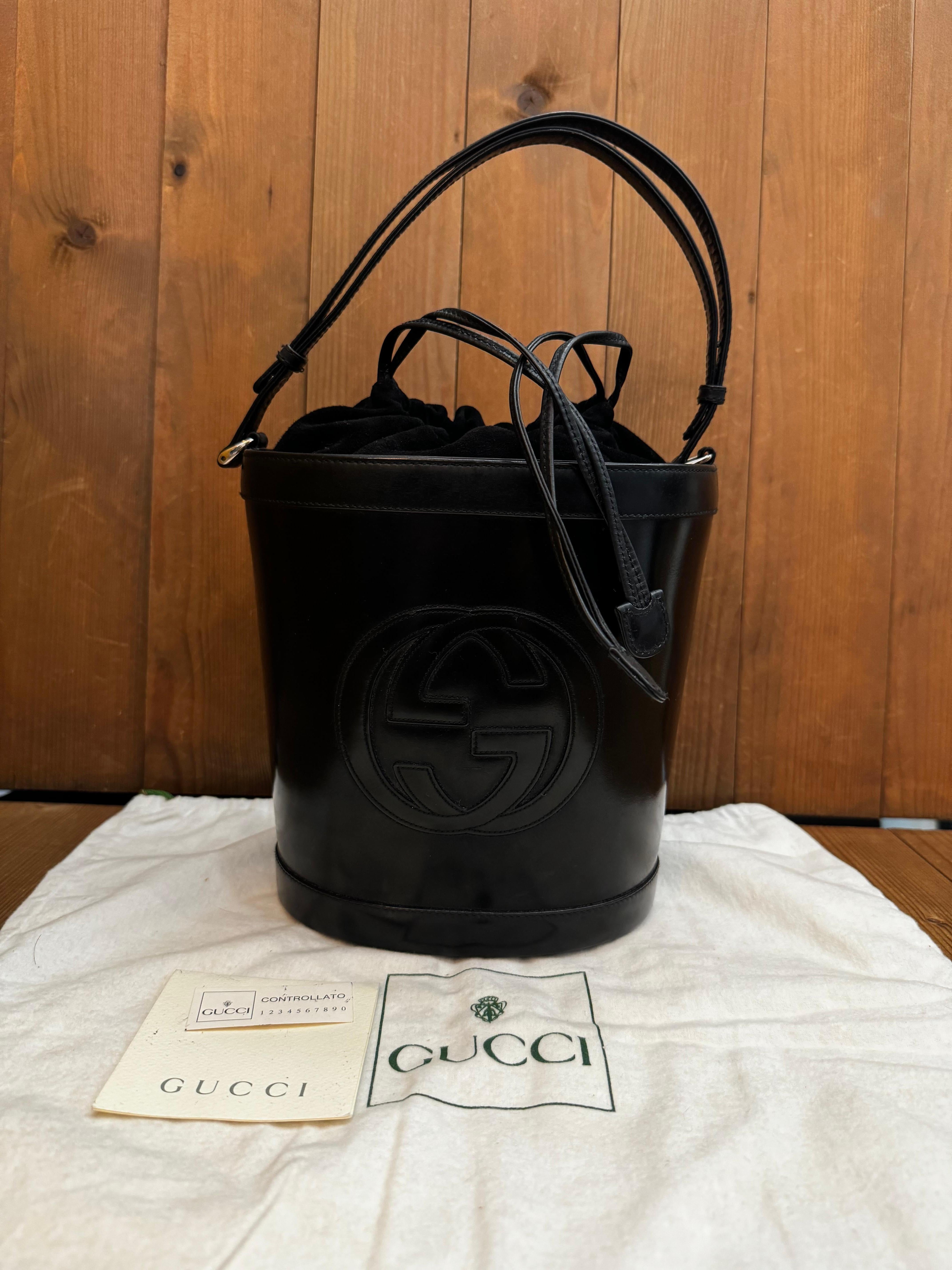 Ce sac seau vintage à double sens de Gucci est confectionné en cuir de vachette lisse et en cuir nubuck de couleur noire. La fermeture à cordon en cuir nubuck ouvre sur un intérieur enduit qui a été nettoyé par des professionnels et qui comporte une