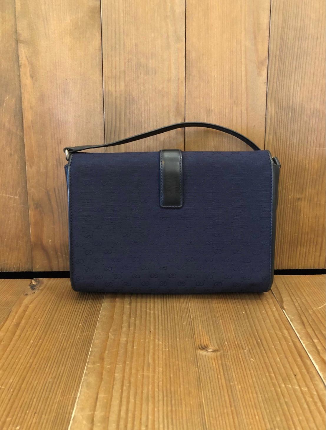 Diese Vintage GUCCI Umhängetasche ist aus Micro-GG-Jacquard in navy gefertigt und mit navyfarbenem Glattleder besetzt. Die Frontklappe mit Drehverschluss öffnet sich zu einem Innenraum aus marineblauem Leder mit einer Reißverschlusstasche.
