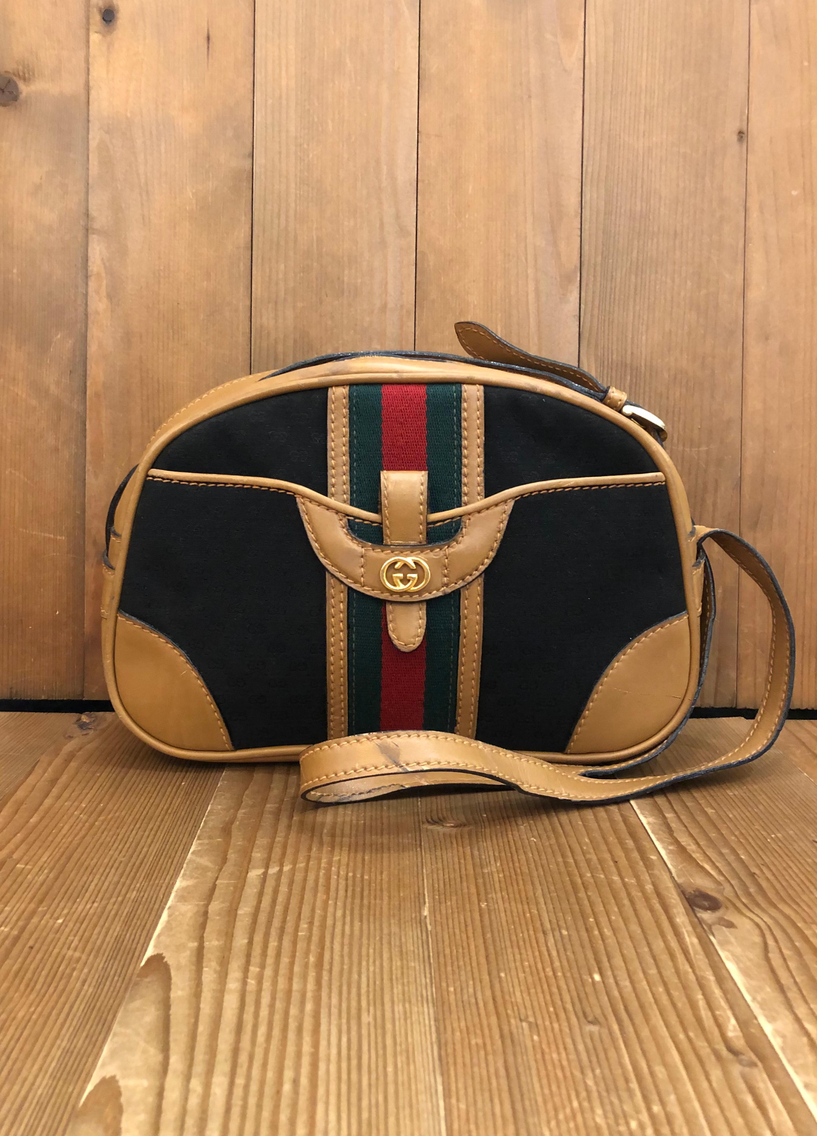 This 1970s Vintage GUCCI shoulder bag is crafted of micro GG jacquard in navy trimmed with beige smooth leather and decorated with Gucci's iconic blue/red stripe. This shoulder bag features a patch pocket at the front. Top zipper closure opens to a