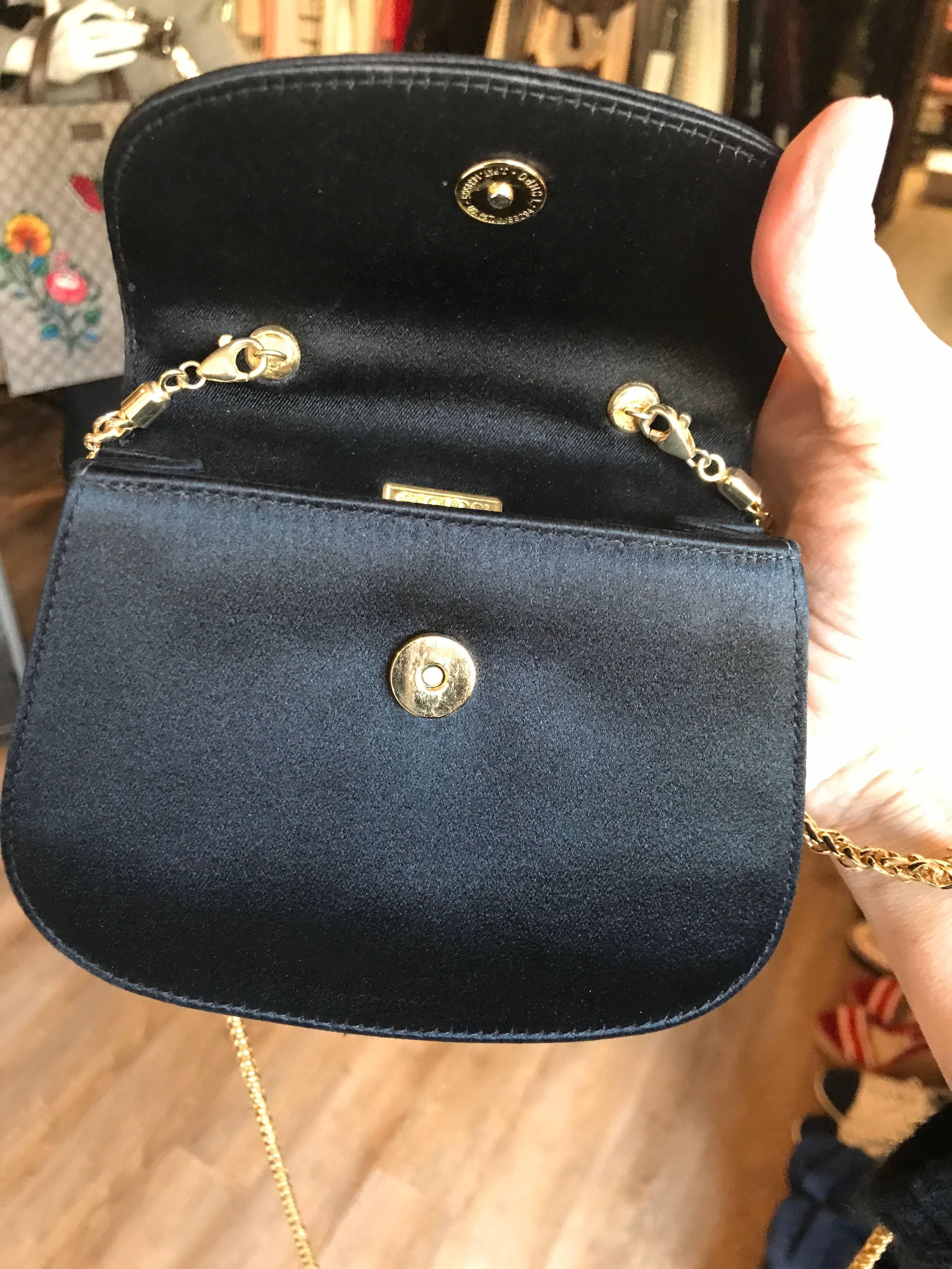 Rare Mini 4 x 5 inch Vintage Gucci bag featured in black satin with a bamboo handle and long gold chain. Bag has a snap closure and an optional gold chain that is long enough to make this a necklace or cross body shoulder bag. Fully lined in satin