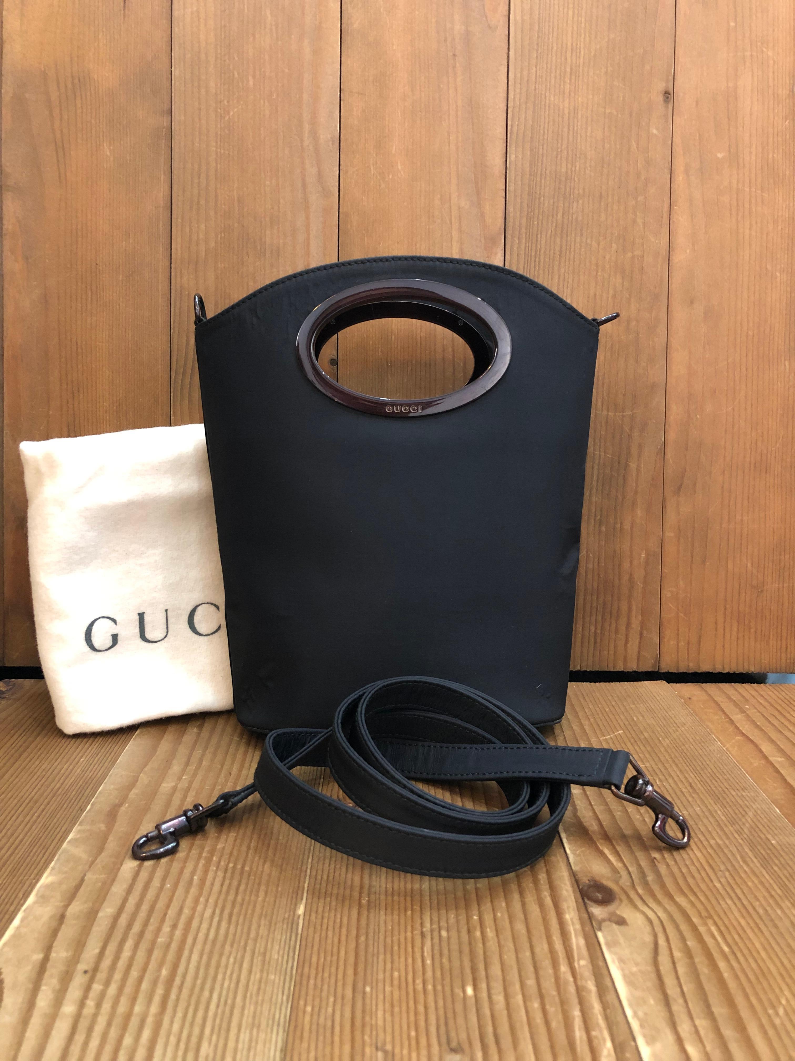 This vintage GUCCI mini two-way bucket crossbody hand bag is crafted of polyester in black featuring black enameled hardware. Wide top handles open to a black diamanté jacquard interior featuring open and zippered compartments. Detachable polyester