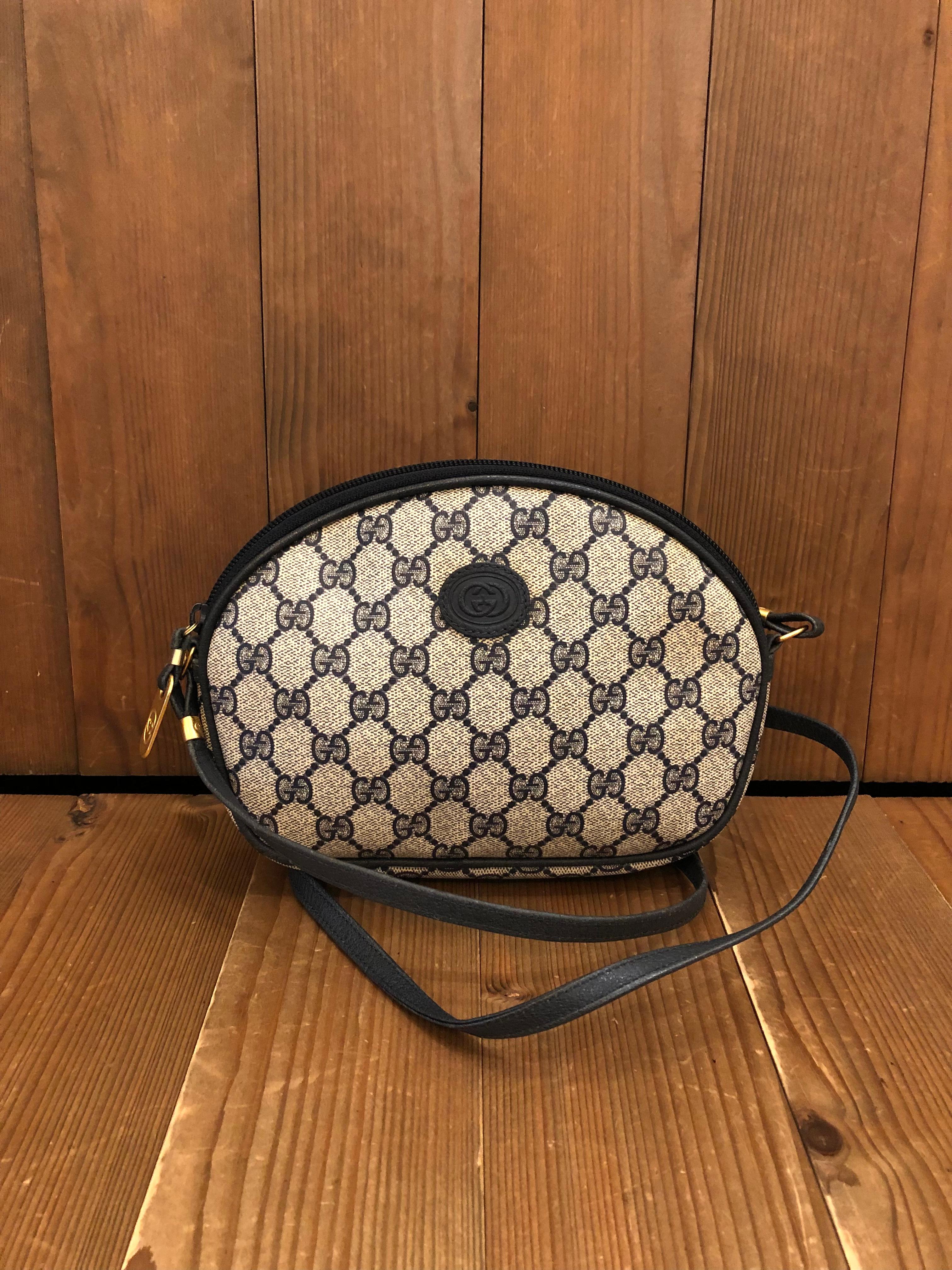 This vintage GUCCI crossbody bag is crafted of monogram canvas and leather in navy. Zipper top closure opens to an interior which has been professionally cleaned featuring a zippered pocket. Made in Italy. Measures approximately 8.75 x 6 x 1.75