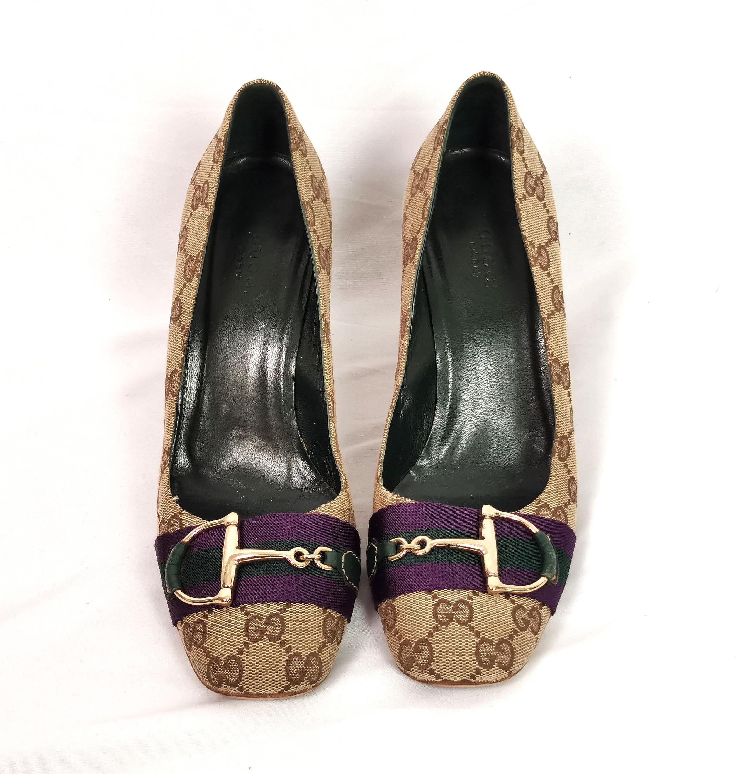 Iconic vintage early 2000s Gucci pumps.

These are signature monogram canvas covered, Heeled pumps with a gorgeous stacked heel and a gold tone horsebit embellishment to the toe.

The horsebit design is laid on a dark purple and green grosgrain