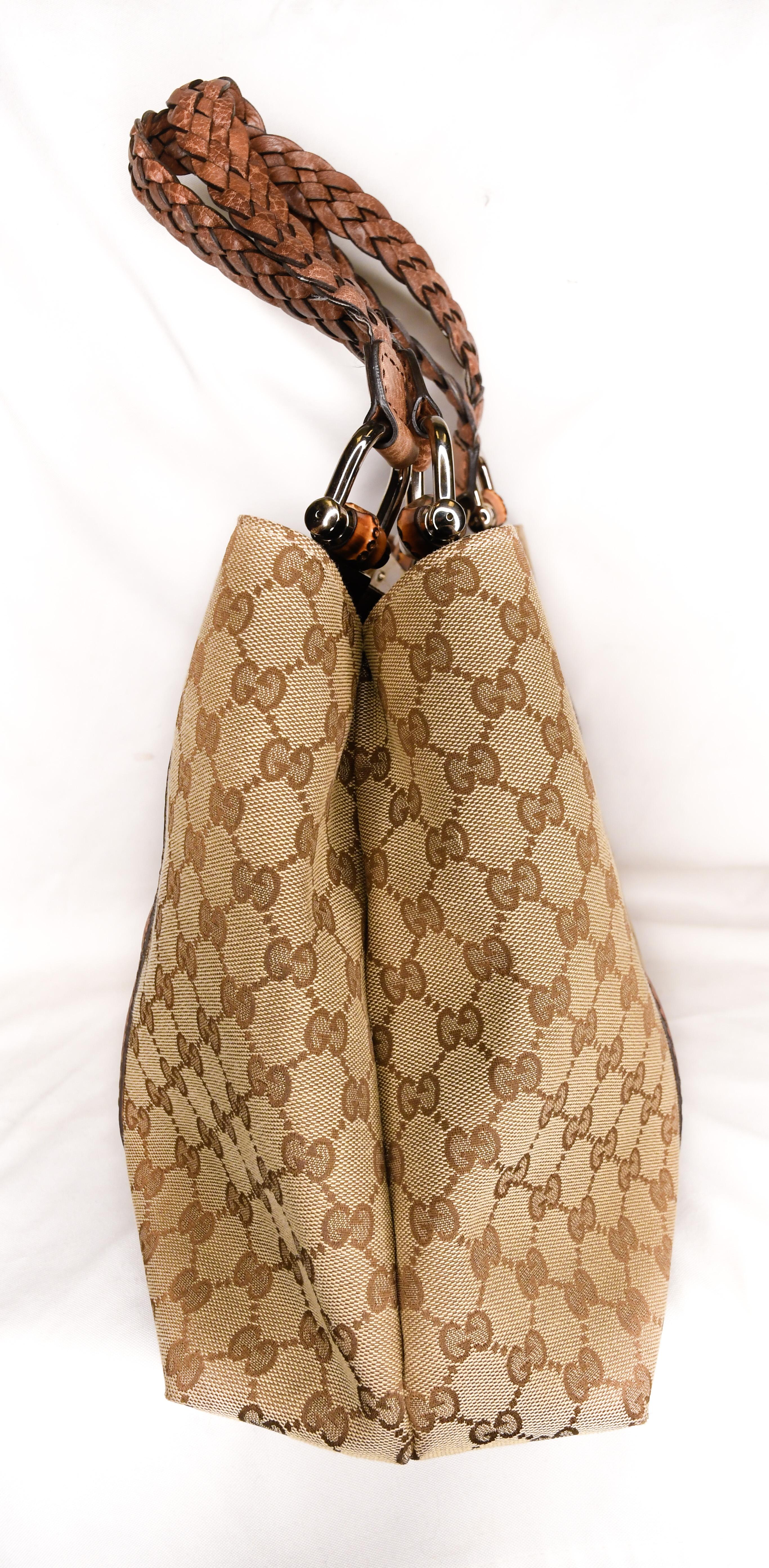 Vintage Gucci monogram tote features iconic logo pattern allover, braided straps and bamboo accents on D rings.   Brown logo jacquard fabric Interior has three large compartments.  Middle compartment is zippered.  Two accessories pockets and one