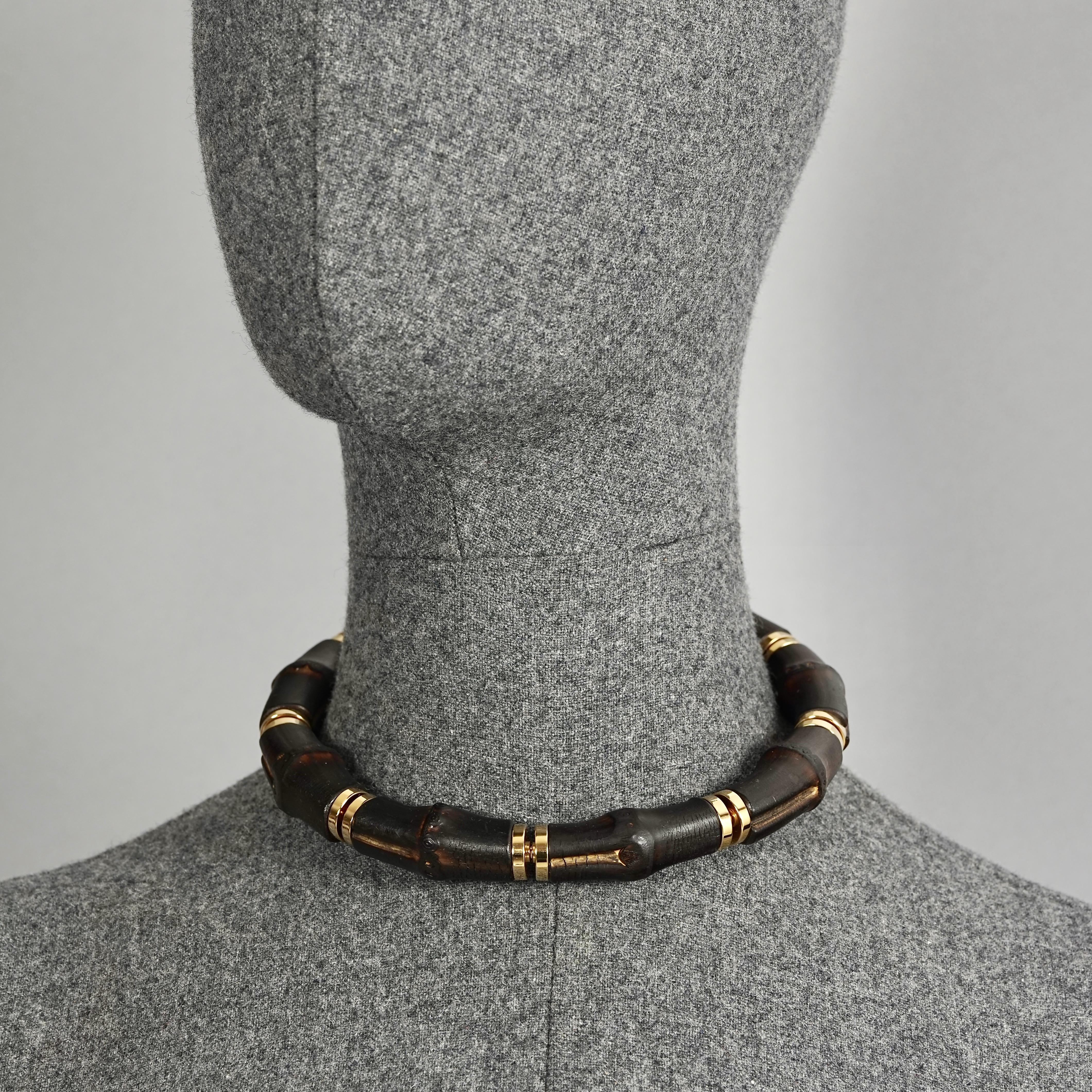 Vintage GUCCI Natural Bamboo Rigid Choker Necklace

Measurements:
Height: 0.71 inch (1.8 cm)
Inner Circumference: 13.78 inches (35 cm)

Features:
- 100% Authentic GUCCI.
- Natural bamboo choker.
- Gold tone hardware.
- Signed GUCCI Made in Italy.
-