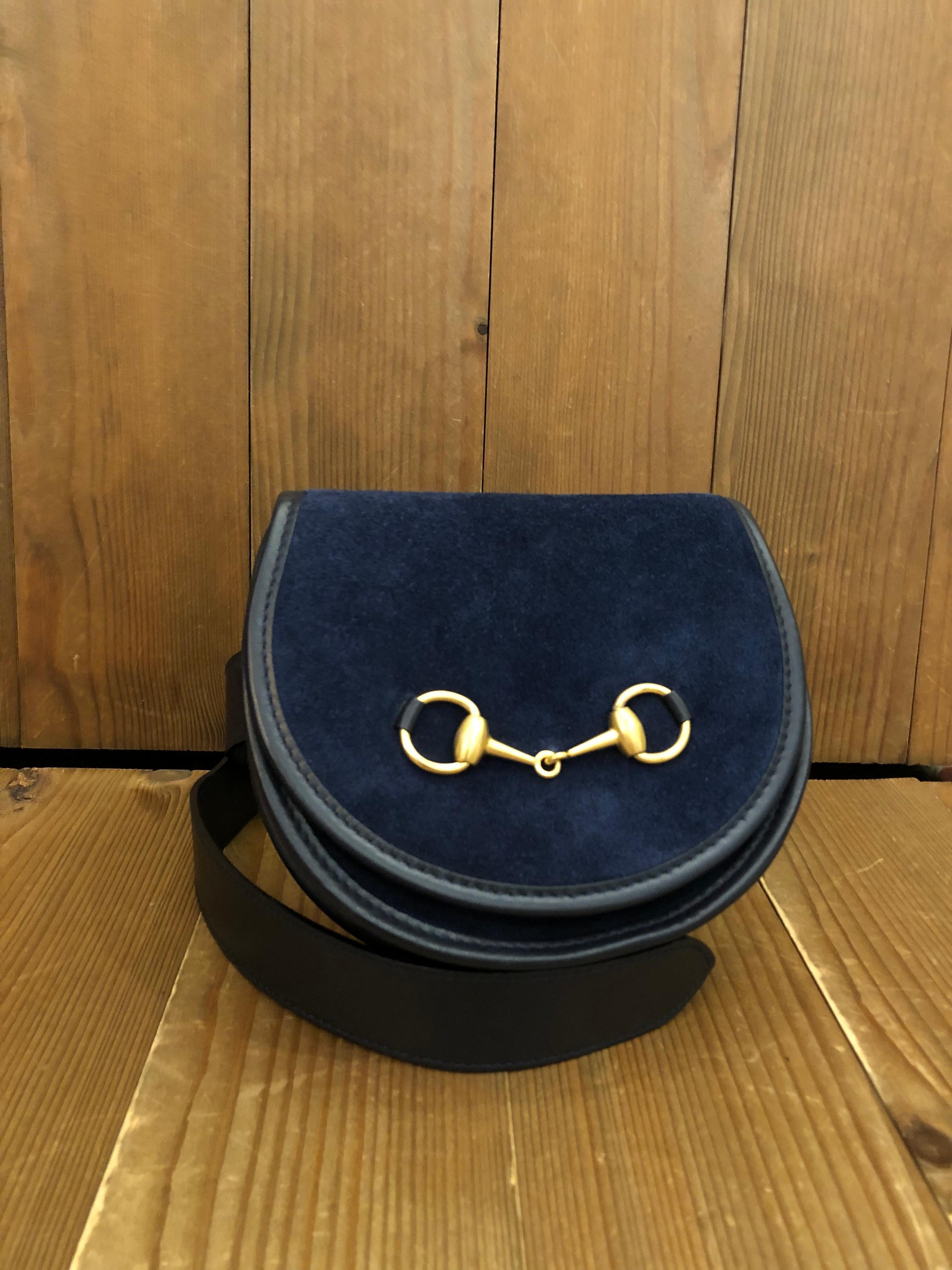 This vintage GUCCI belt bag is crafted of suede and calf leather in navy featuring a gold toned horsebit. This Gucci belt bag comes with a detachable belt of the same leather. Front flap magnetic snap closure opens to a coated interior which has