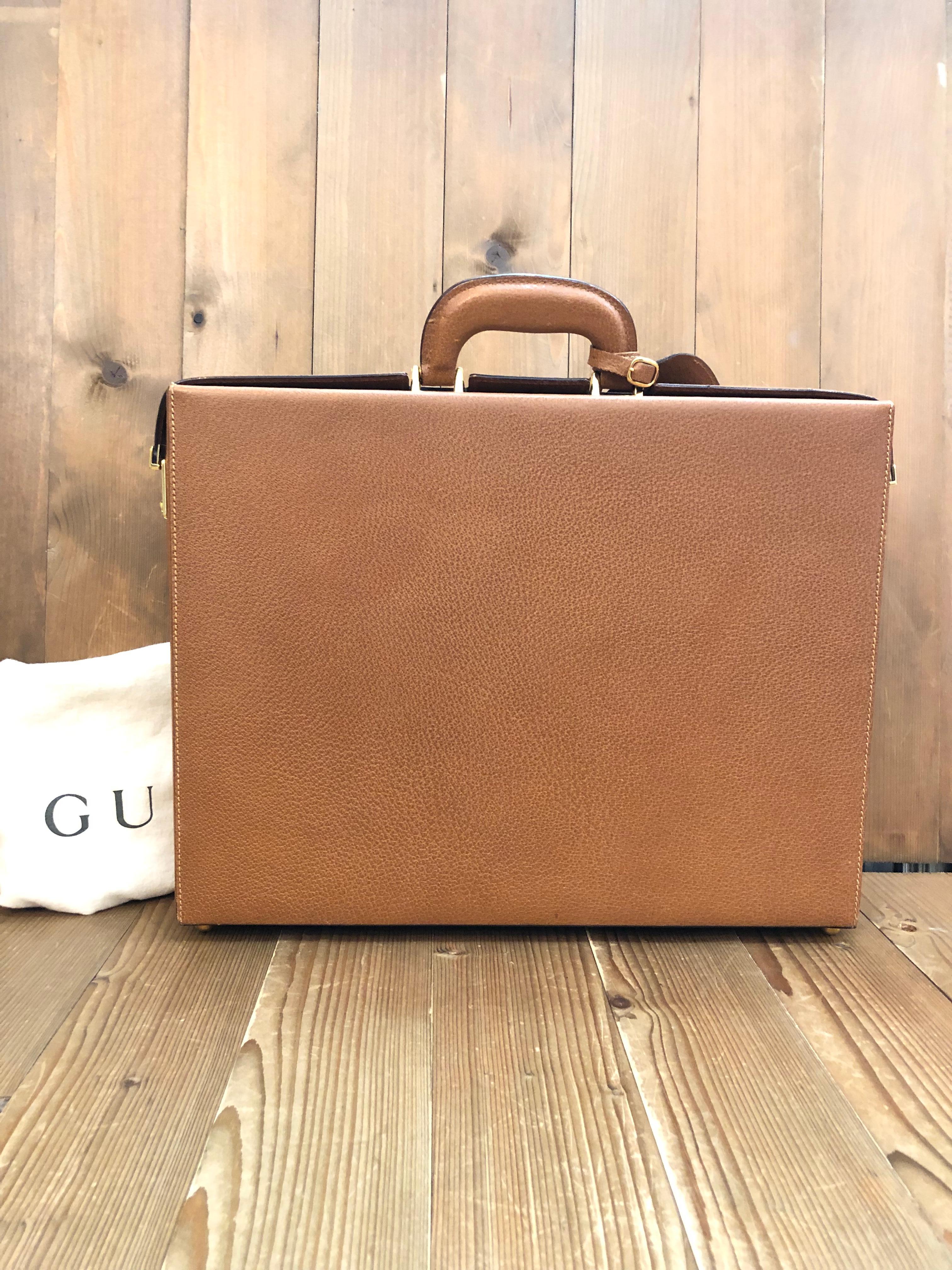 This vintage GUCCI trunk briefcase is crafted of pigskin leather in caramel featuring gold toned hardware. Double side lock closures opens to a luxurious nubuck leather interior in beige featuring pockets and holders of the same leather. Made in