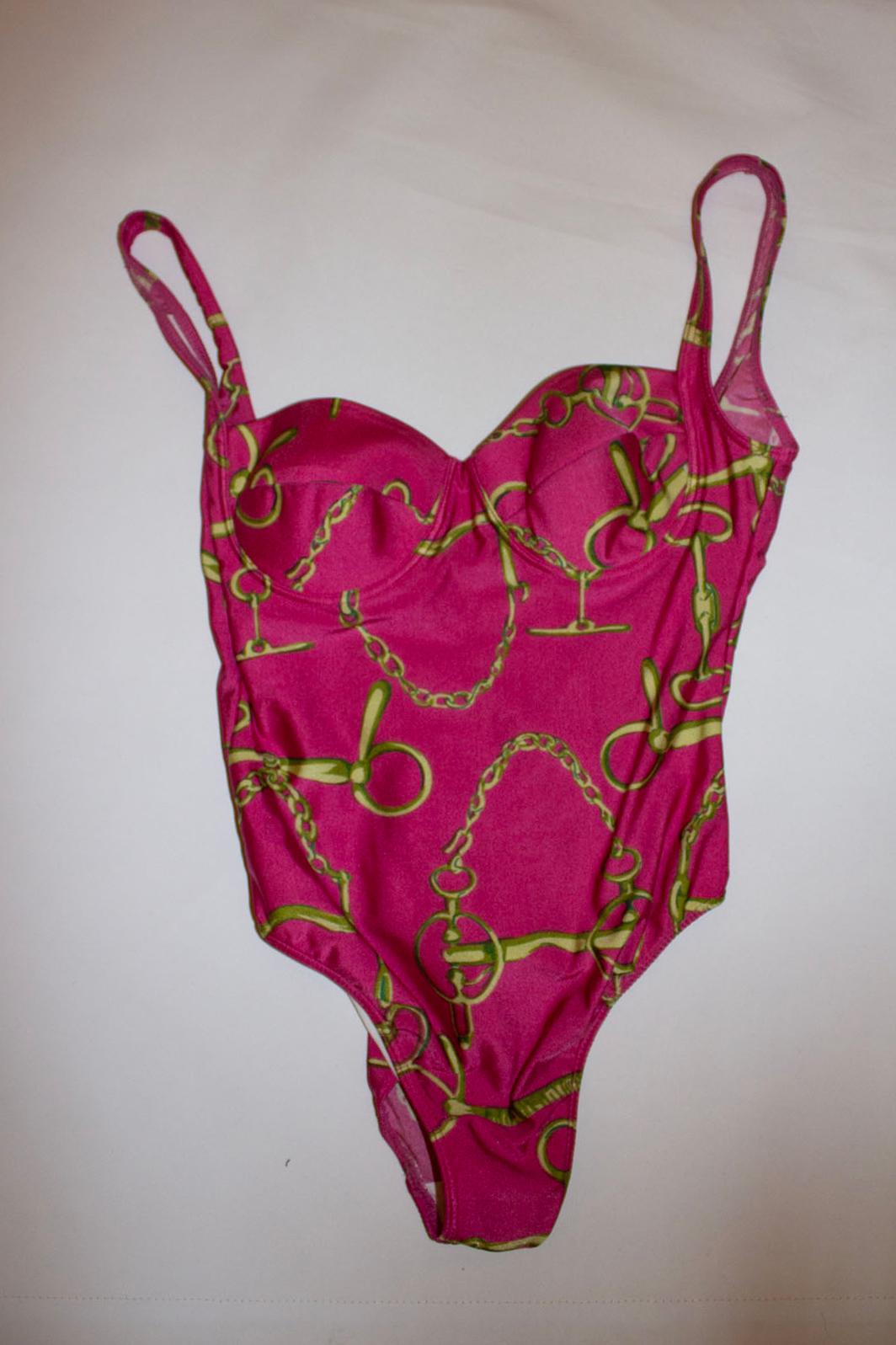 A headturning vintage swimsuit by Gucci. In a pretty pink and gold print, the swim suit has built in bust cups.
Size M Made in Brazil. Measurements Bust up to 38'', length 27''