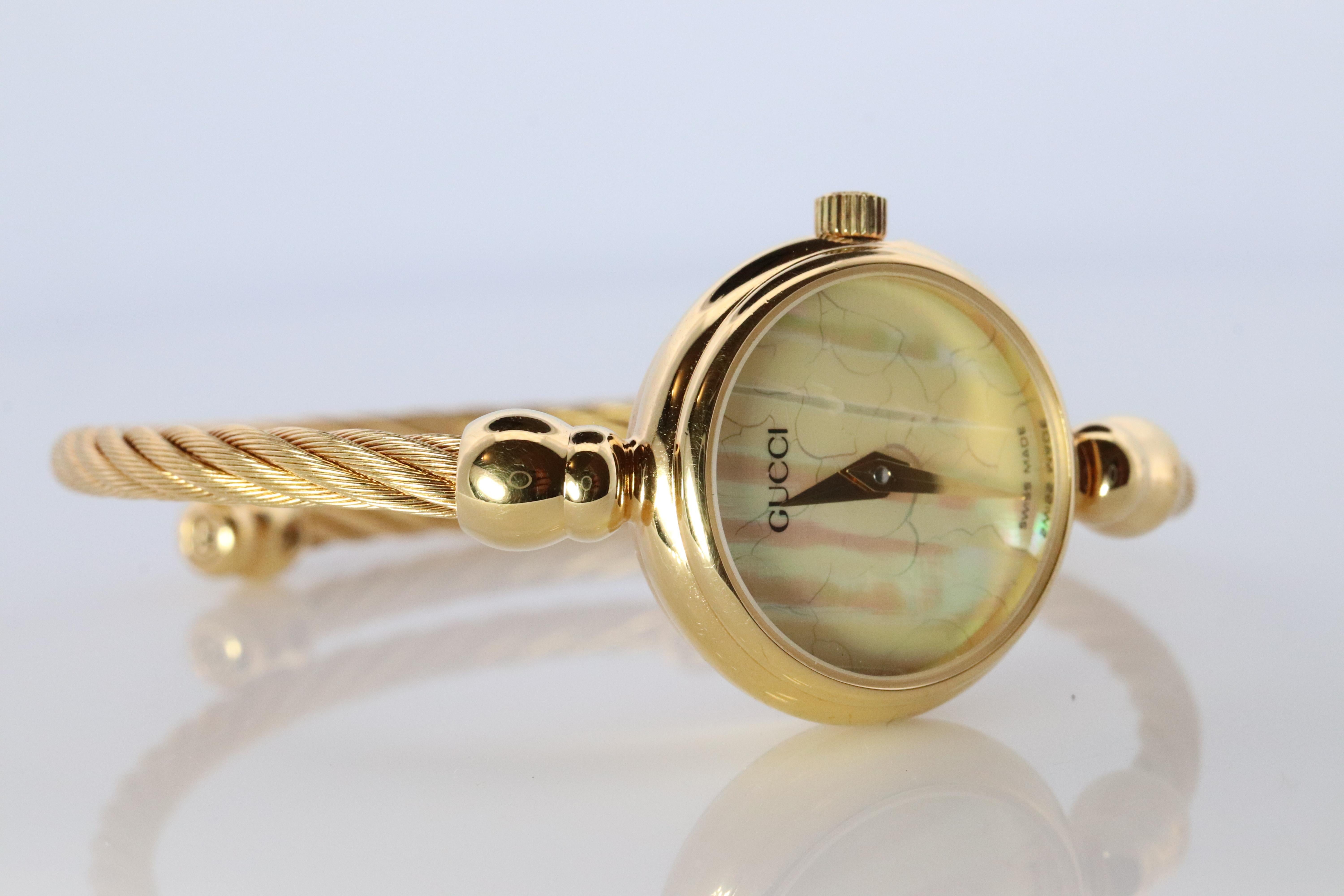 Genuine Gucci Watch.

2700.2.L Reference number.

Gold Tone 

Condition: New battery. 

Details:
20mm round Case
Original Box with Original International Warranty card and Paperwork.