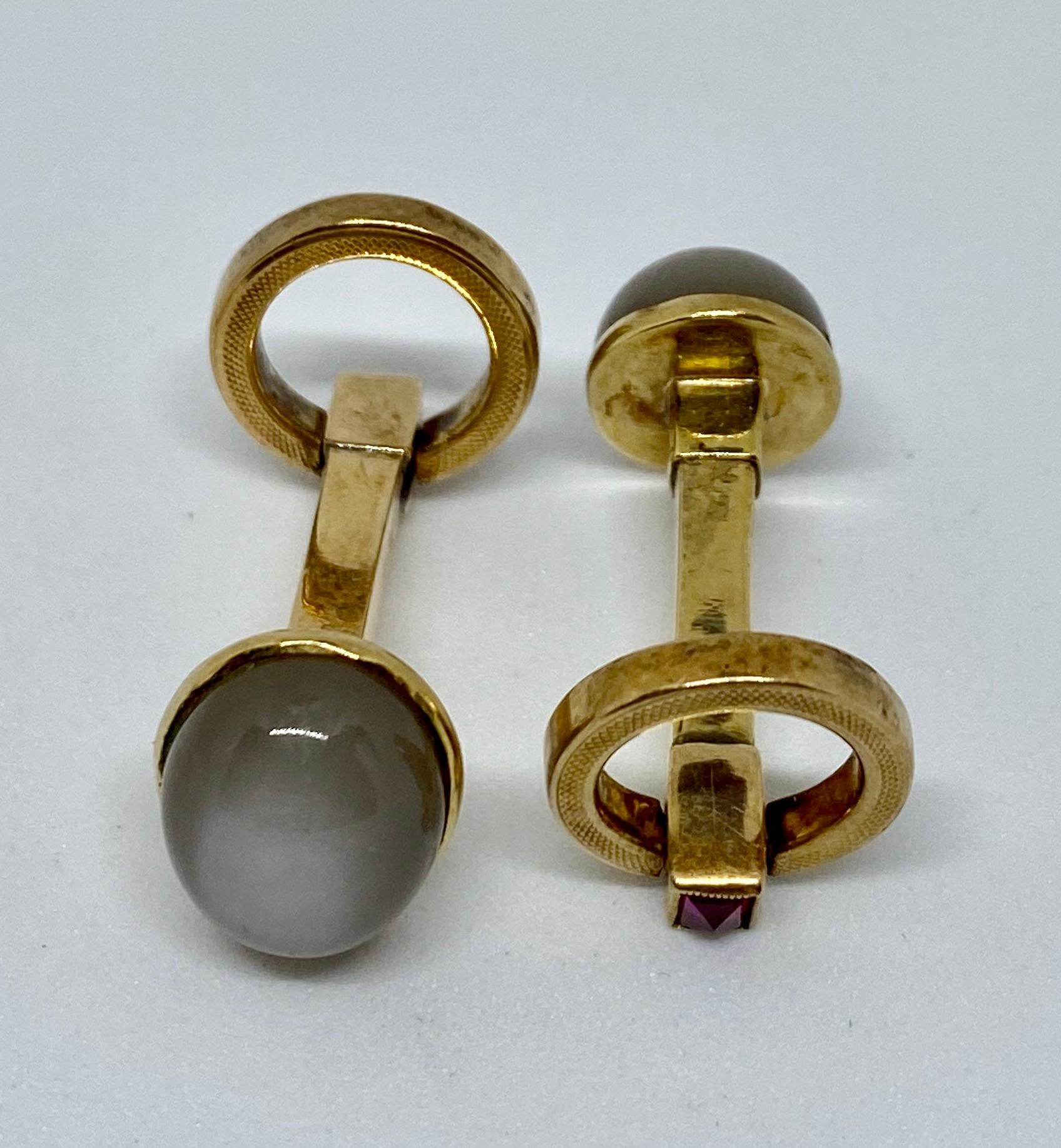 These vintage 1960s Gucci cufflinks epitomize La Dolce Vita. 

Rendered in 18K yellow gold, they feature two large, cabochon-cut moonstones, two machine-engraved, flip-up circles, and two pyramid-cut amethysts at the terminals.

The moonstone ovals