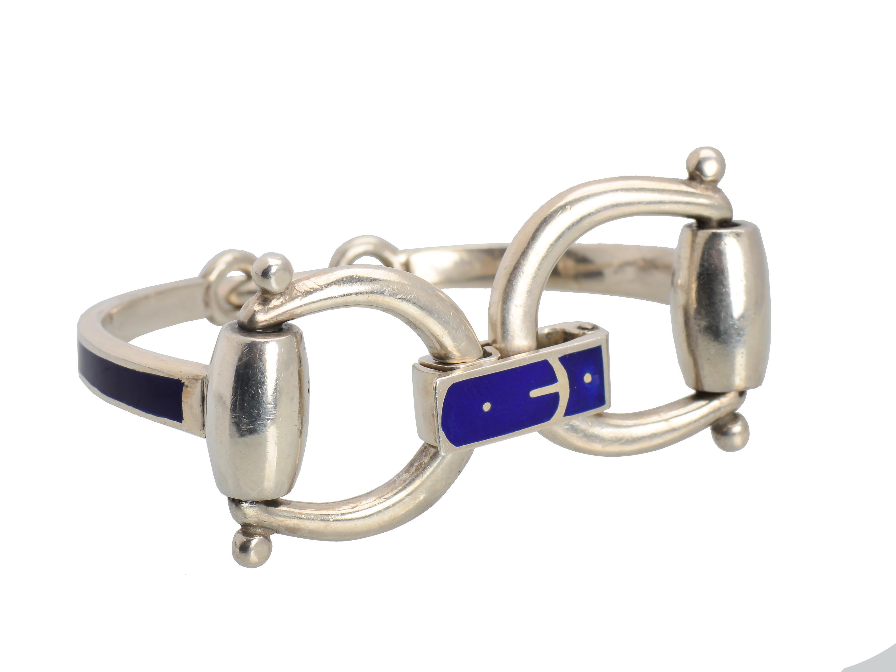 The Iconic design of this sterling silver and blue enamel bracelet is quickly recognizable as a Gucci equestrian design bracelet. The bangle has a bridal bit and buckle closure. This is a scarce example of this vintage bracelet that has always been