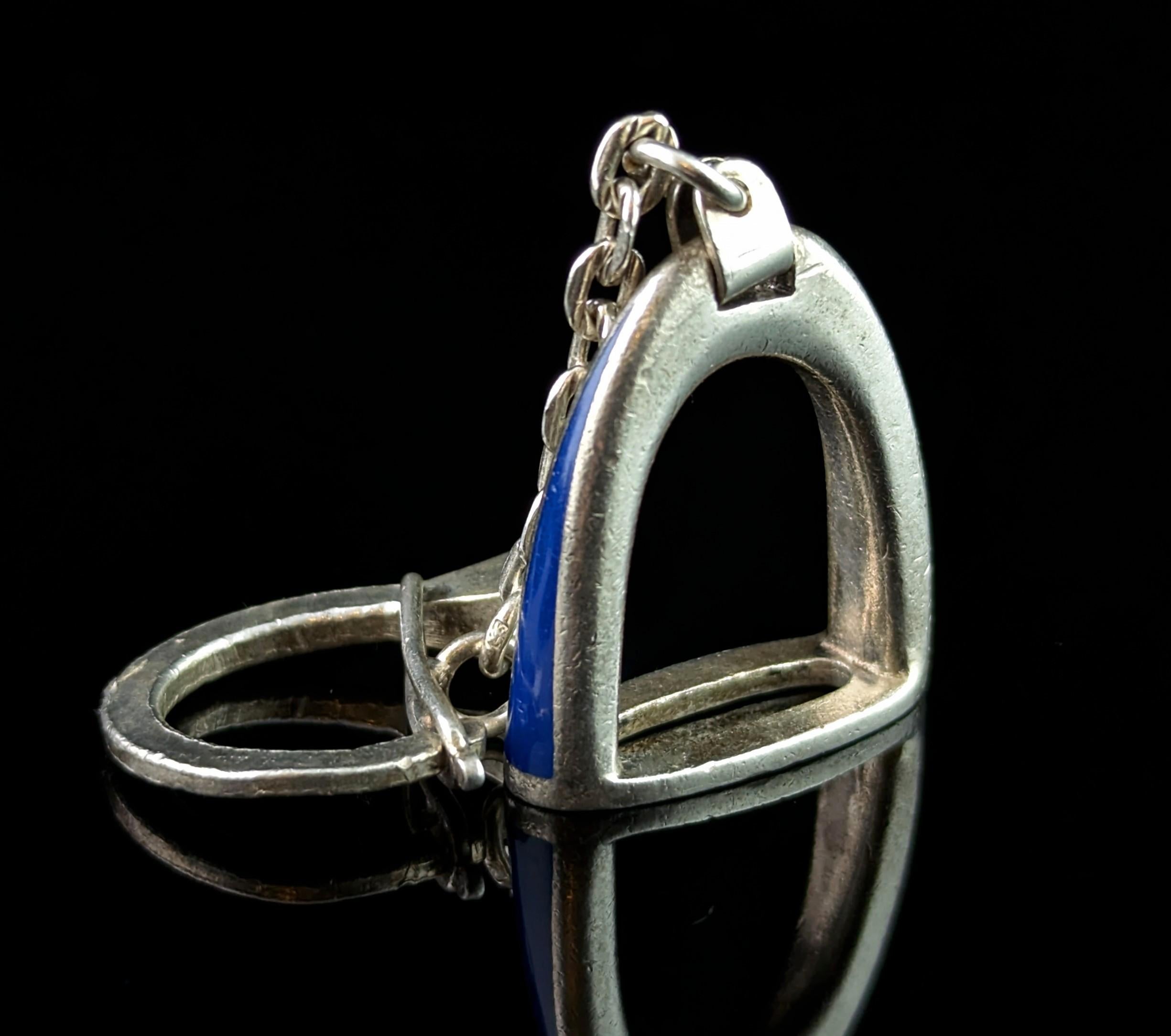 A stylish vintage Gucci sterling silver and Royal blue enamel keyring or charm.

A classic and timeless piece from the late 90s, it features a heavy silver stirrup with the dark blue enamel running down each side.

It is connected with a short chain