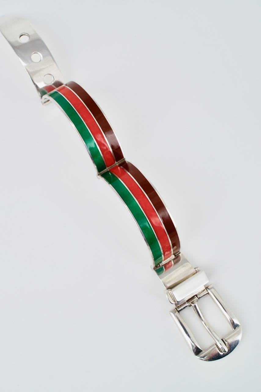 An iconic Gucci solid silver brown red and green enamel belt buckle bracelet consisting of two hinged panels of three stripes with a central red stripe bordered by a dark brown and a green stripe with a hinged working buckle and three hole hinged