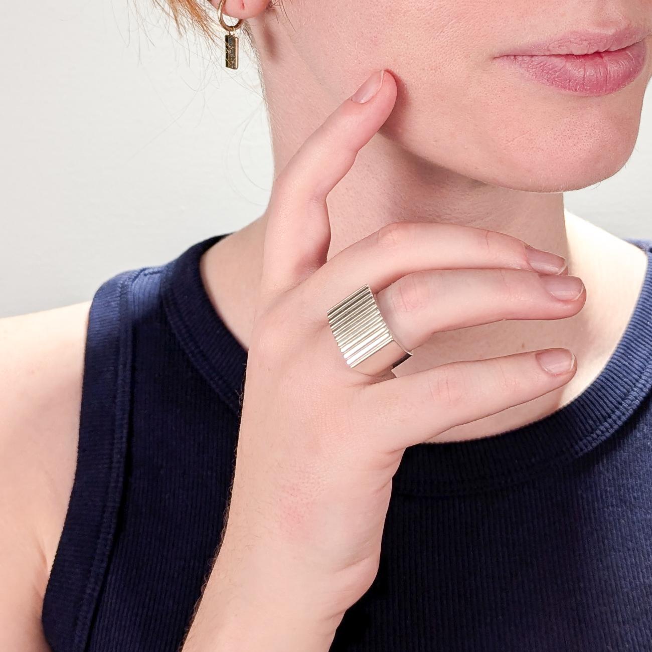 A fine vintage designer silver signet ring.

By Gucci.

In sterling silver.

With a rectangular face and an engraved striped, parallel line pattern.

Marked to the interior with Gucci's maker's mark / Made in Italy / 925 / and Italian
