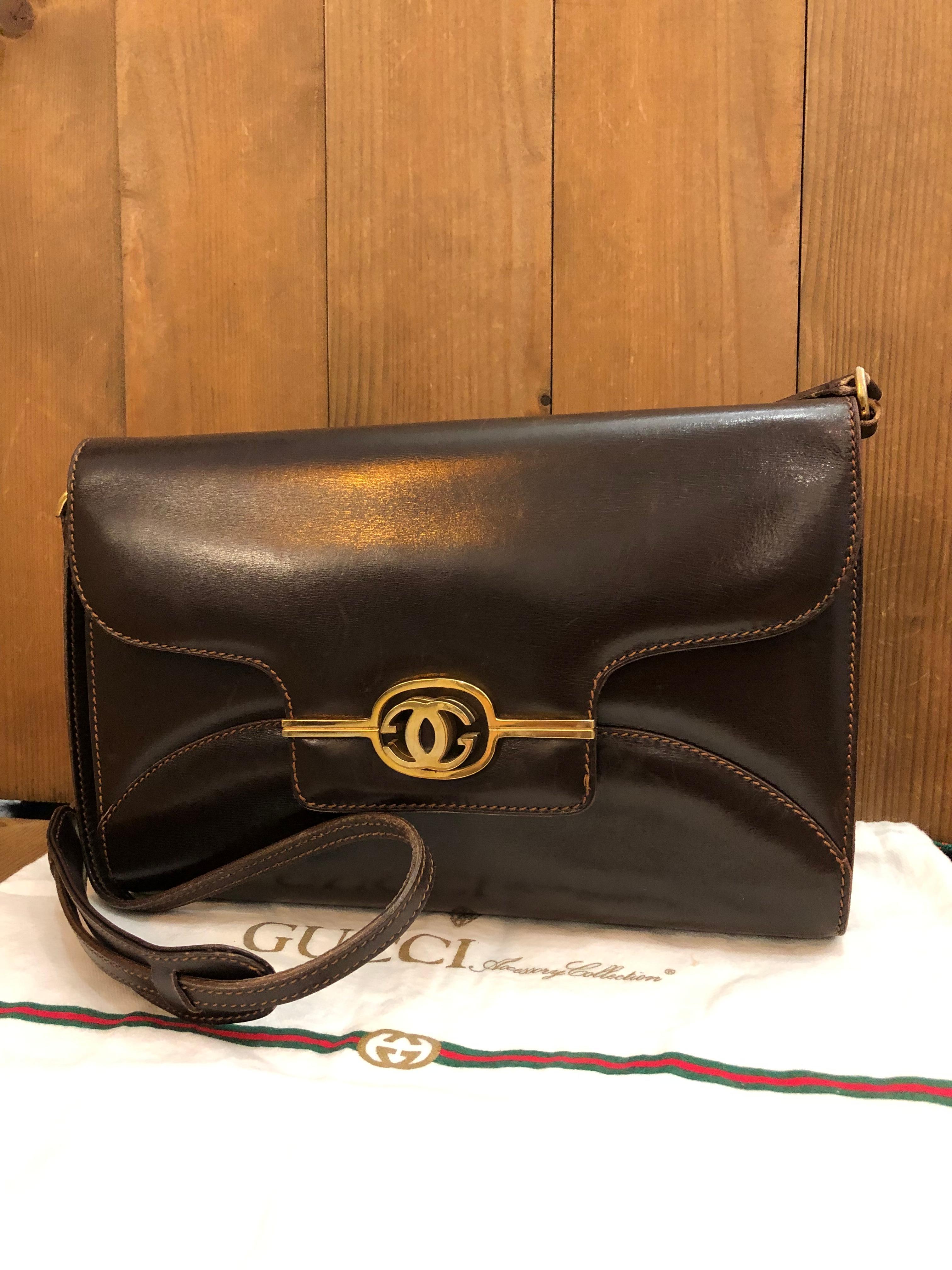 This vintage GUCCI two-way clutch shoulder bag is crafted of smooth calfskin leather in dark brown featuring gold toned hardware. Front flap huge GG turnlock closure opens to a brown leather interior featuring a patch pocket. This vintage Gucci