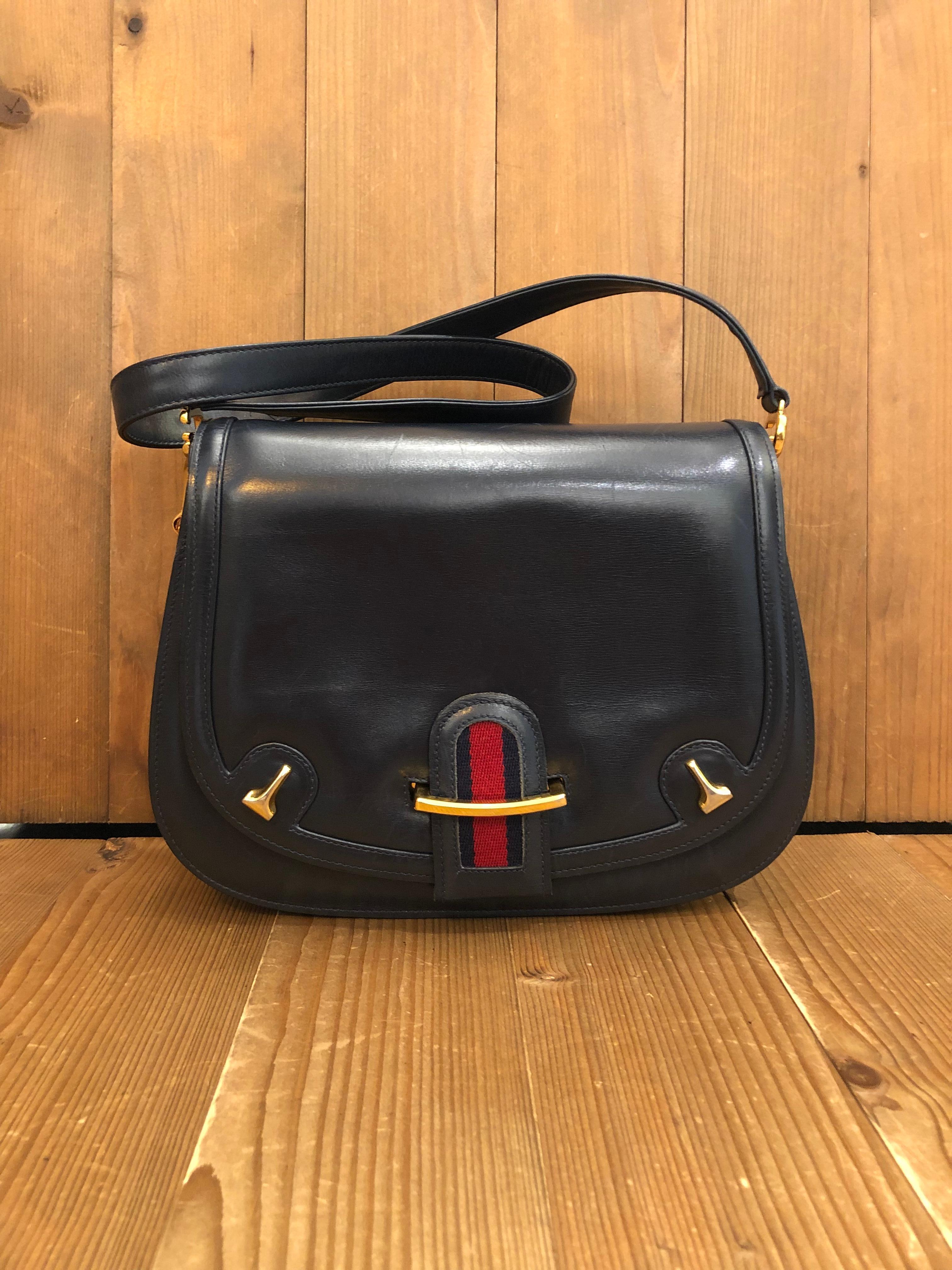 This 1970s vintage Gucci shoulder bag is crafted of smooth leather in black featuring Gucci’s iconic red/blue web buckle adorned with gold toned equestrian accents. Front flap closure opens to a black leather interior with zippered and open pockets.