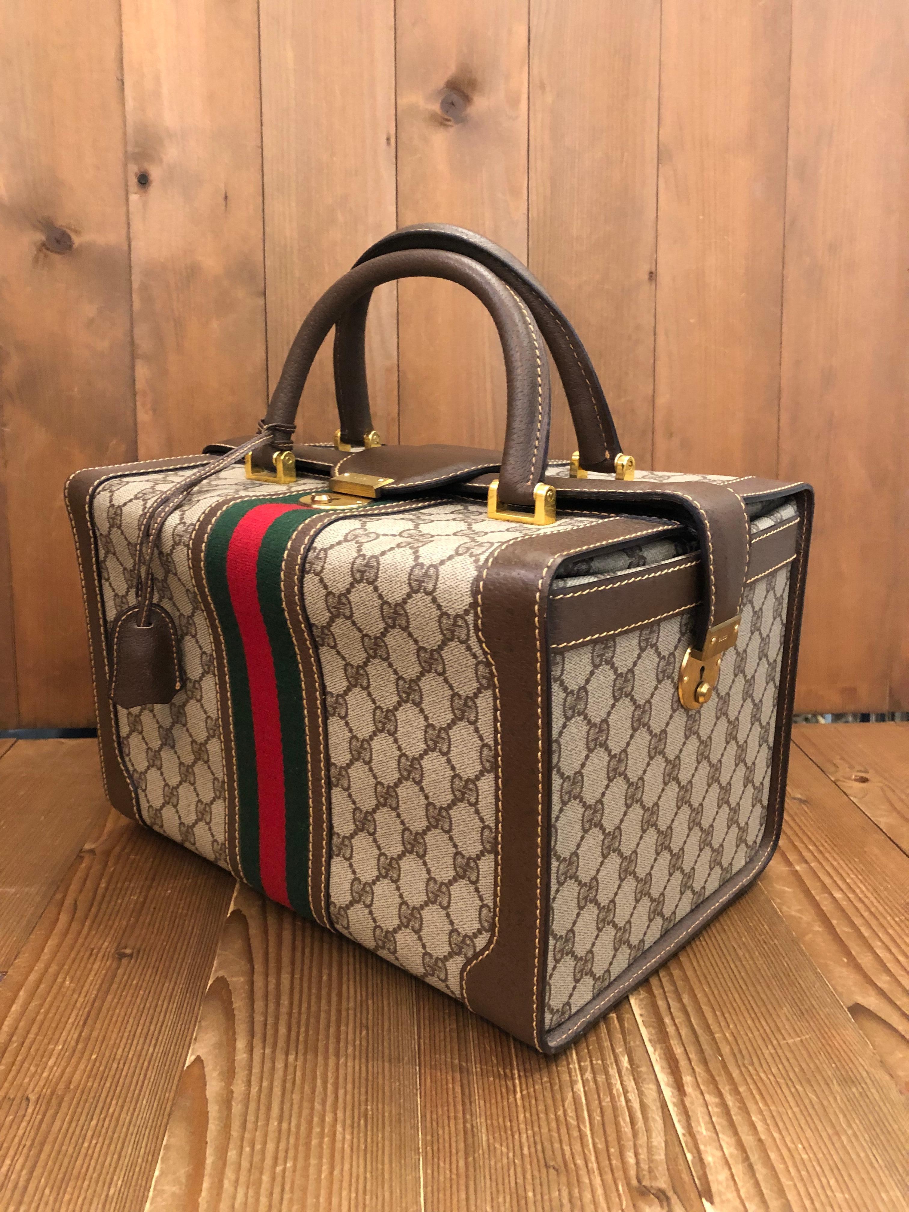 This 1980s vintage GUCCI soft-sided vanity trunk is crafted of GG monogram coated canvas in brown decorated with Gucci’s iconic red/green Web band trimmed with brown pigskin’s leather. This vanity bag features three locks with one on top and one on