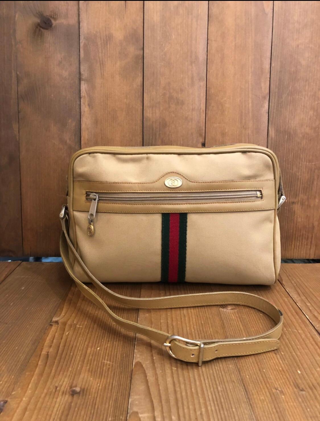 This vintage GUCCI crossbody bag is crafted of nylon in beige decorated with Gucci’s iconic greed/red band. Top zipper closure opens to coated interior in brown featuring a zippered pocket. This crossbody also features a front zippered pocket. Made