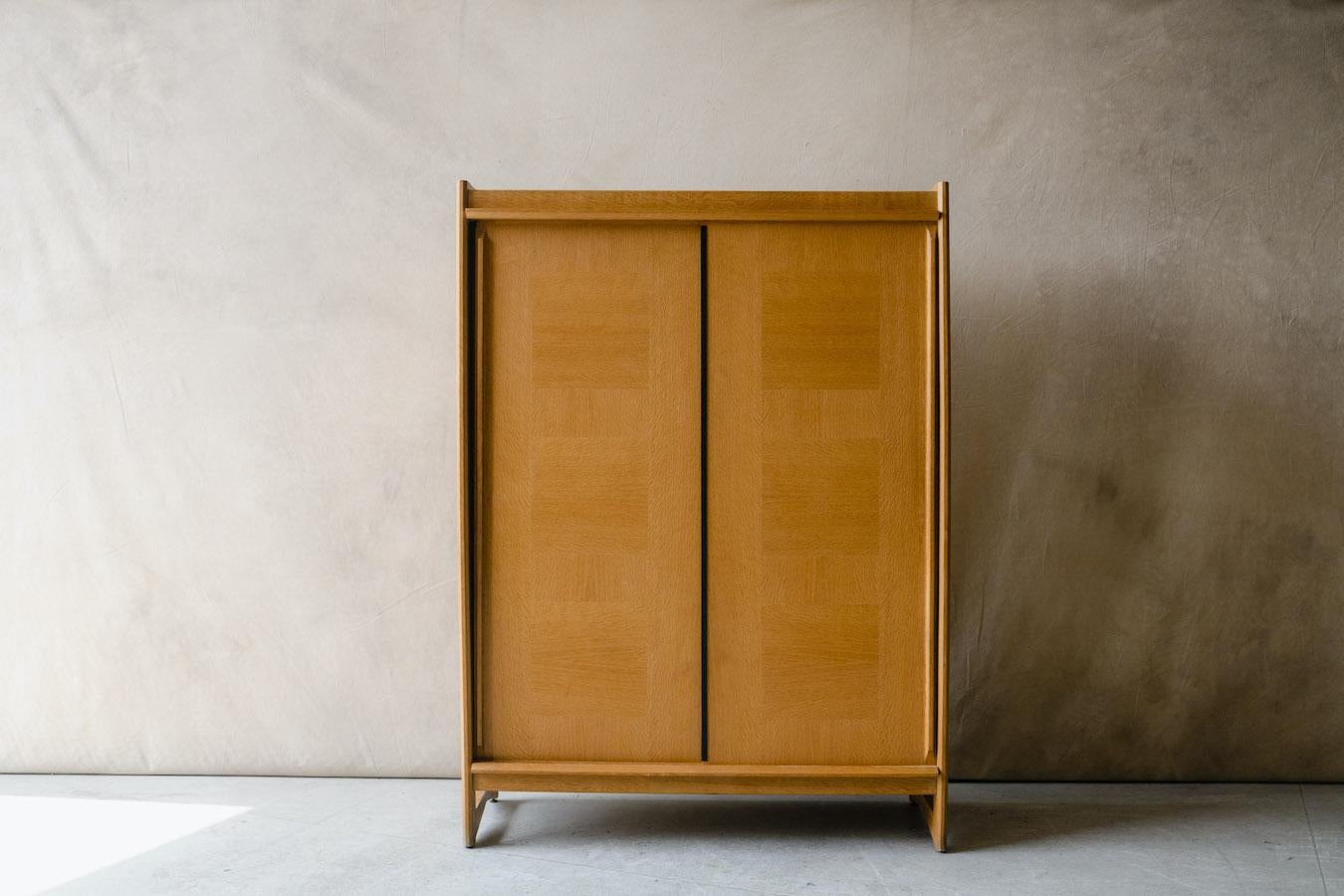 Vintage Guillerme Et Chambron cabinet from France, Circa 1960. Solid oak construction with two sliding doors and adjustable shelves. Very good condition with light wear and use. 

We don't have the time to write an exhausting description on each of