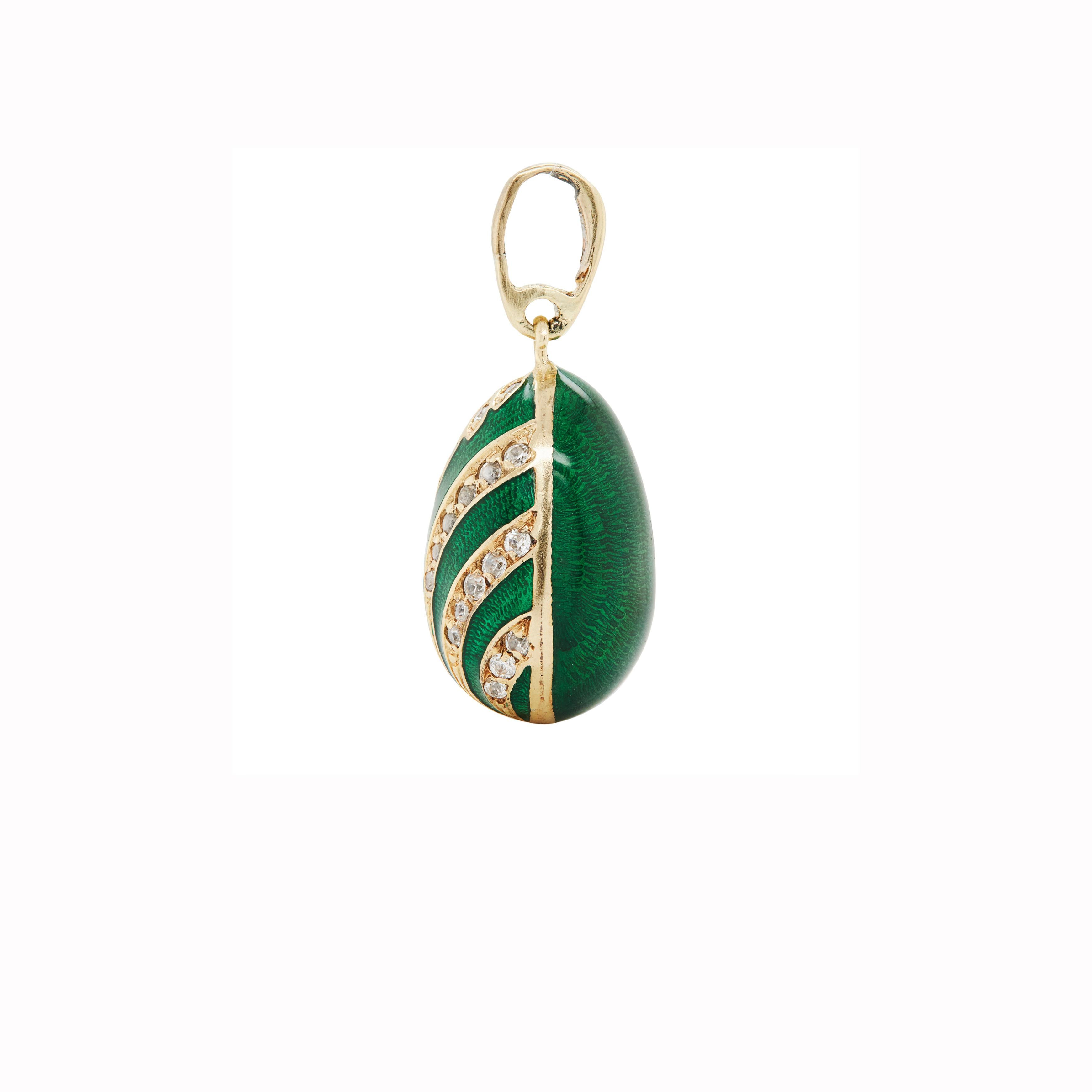 Radiating vintage charm, this 14 carat yellow gold enamel egg charm/pendant is a true conversation piece. 

This piece is mostly covered in emerald green Guilloché enamel, with the front half beautifully accented by delicate, tapered gold stripes