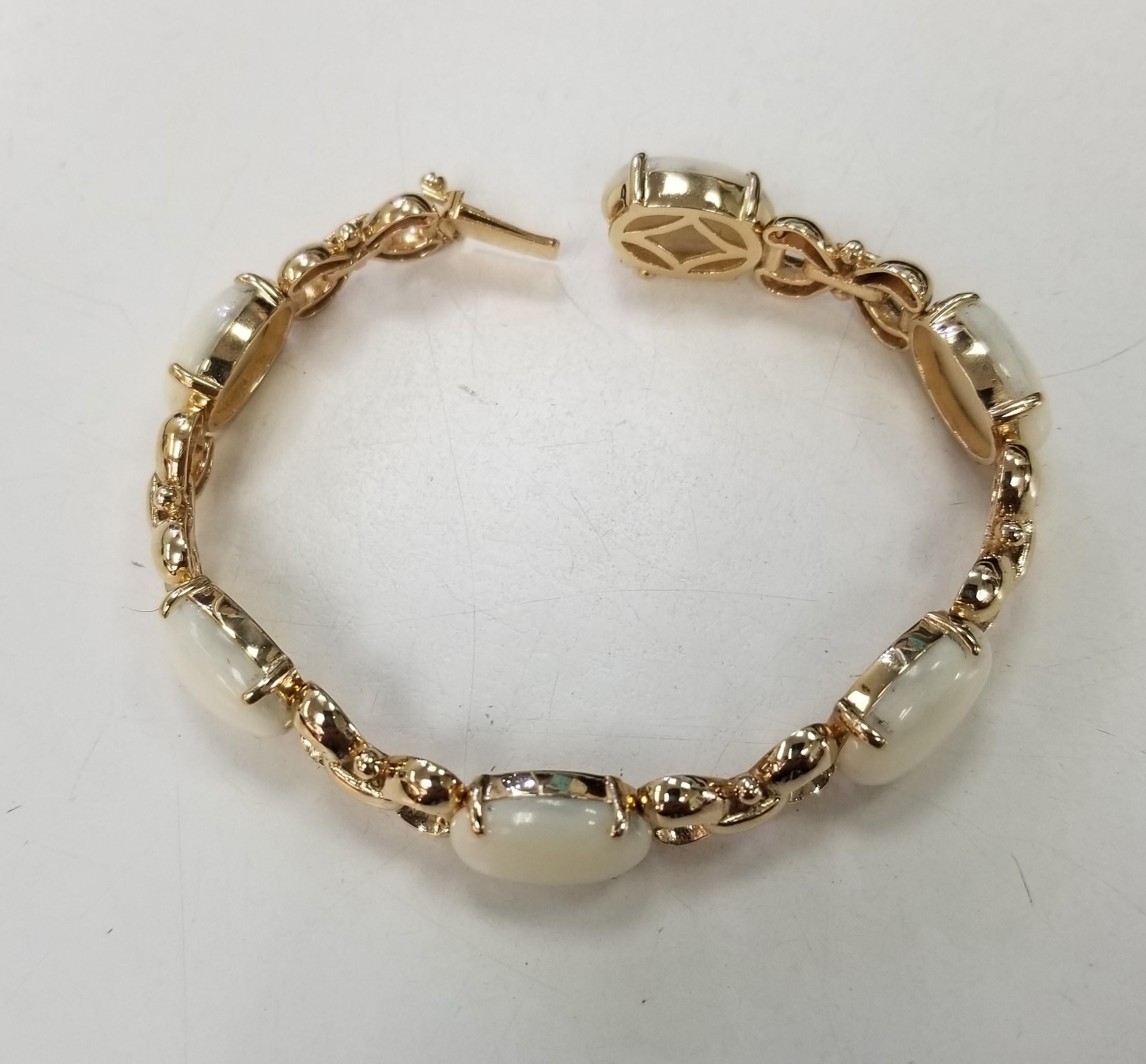  Elegant and finely detailed Link Bracelet, securely Hand set with 6 oval cabochon White Coral stones. Hand crafted in 14 Karat Yellow Gold. The Bracelet epitomizes vintage charm, taking you from day to evening effortlessly. The Bracelet is in