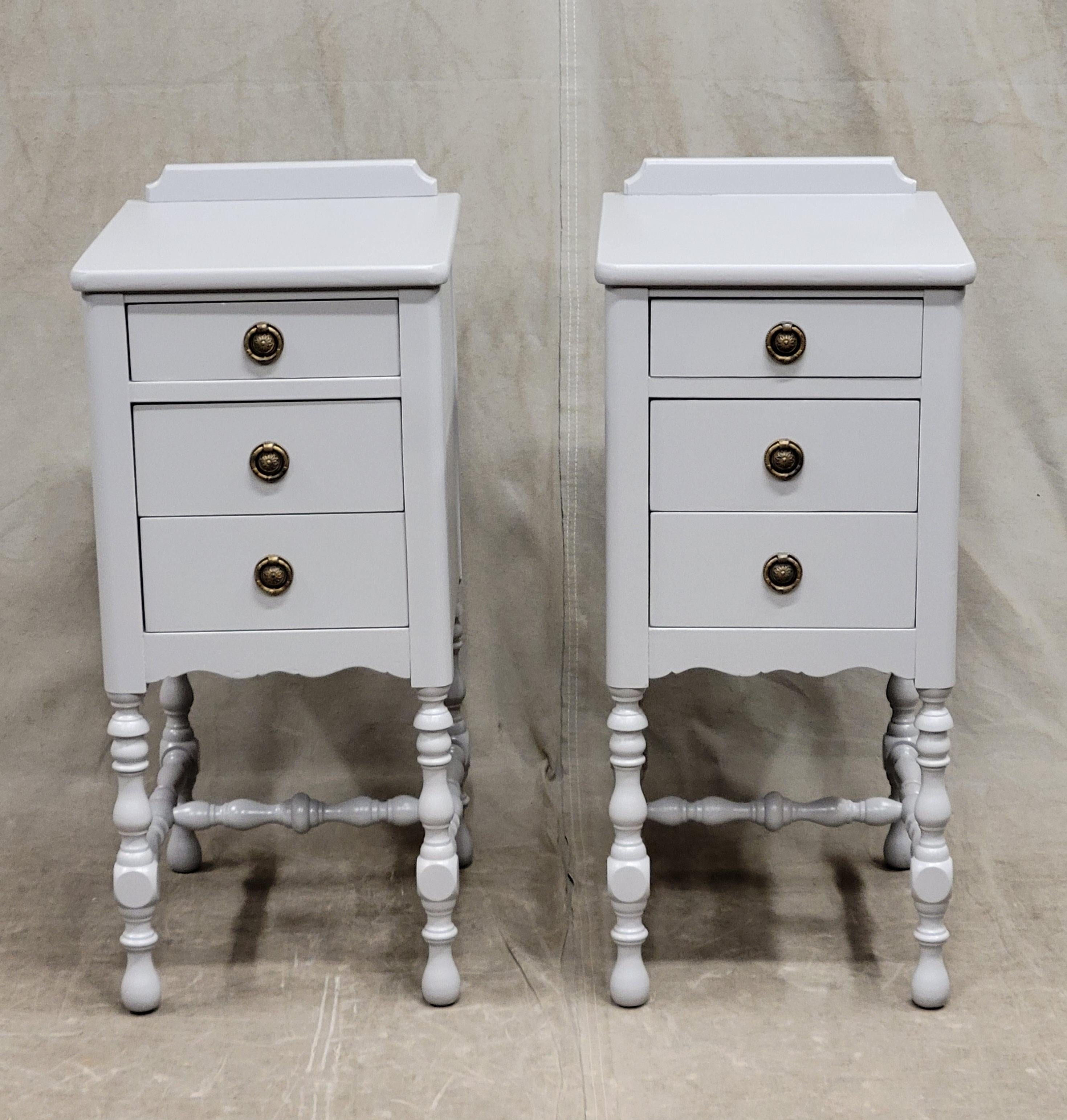 This is a beautiful and functional pair of vintage 1940s nightstands have been recently painted with Gustavian gray paint. Brass drawer pulls are replacements. Three drawers in each nightstand offer ample storage. Turned legs give this set such