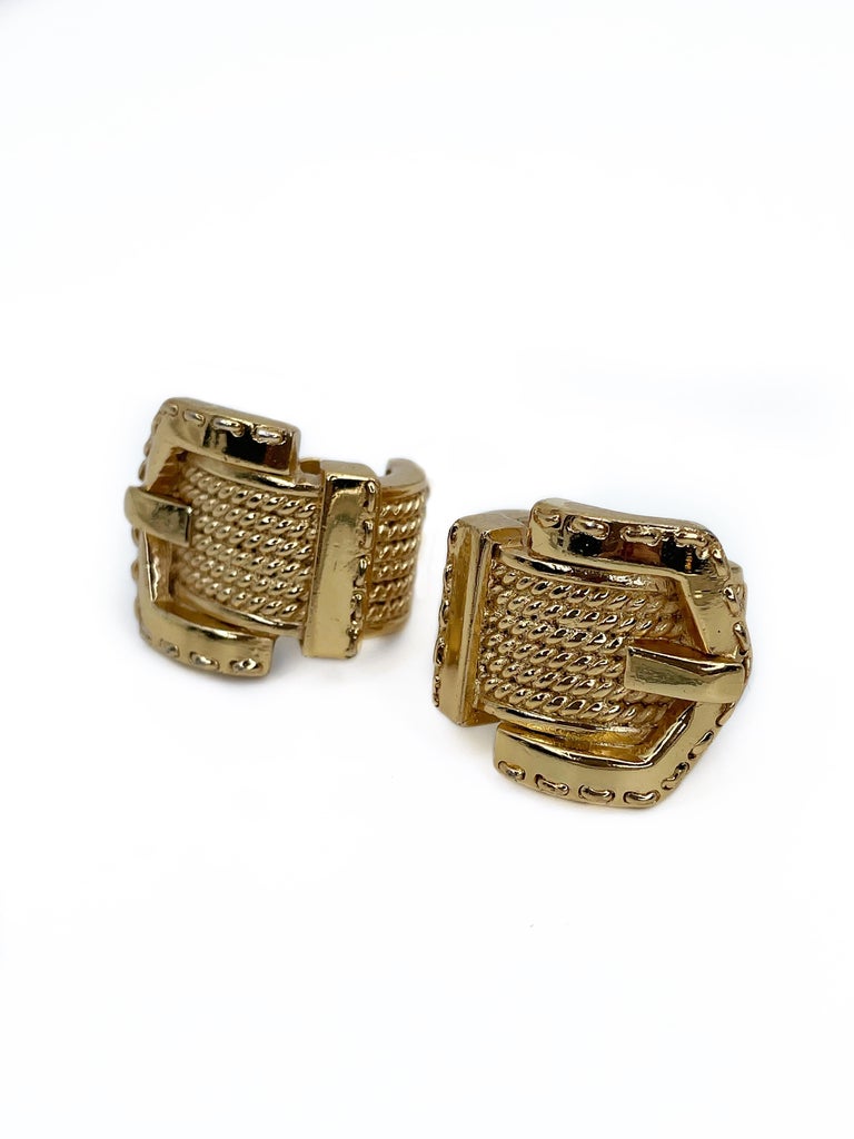 This is a buckle design massive vintage clip on earrings designed by Guy Laroche in 1980’s. This piece is gold plated. 

Markings: “Guy Laroche - Paris©” (shown in photo).

One edge is a bit rubbed off (shown in photo)

Length: 2.7cm
Width: