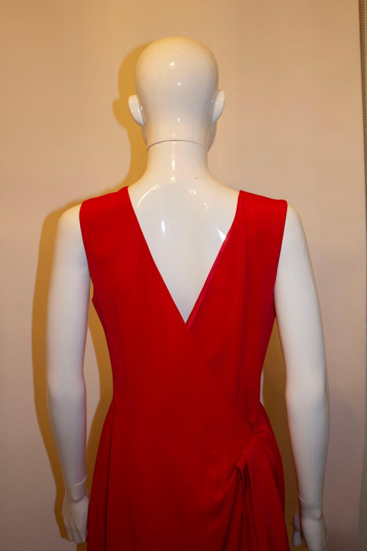 A stunning head turning red vintage gown by Guy Laroche.The long gown , has a v back line , wrap over and zip opening. It is lined in silk . Size 14, bust 38'', length 54'' . The dress has a 23'' slit at the front.