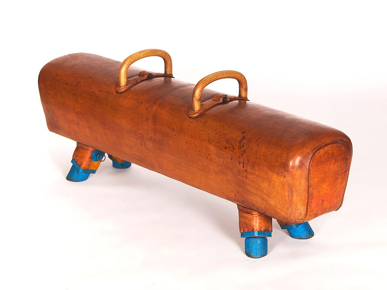 Pommel horse from former Czechoslovakia. The legs were cut to a height of 53cm. The handles can be removed for comfortable seating. The wooden handles were restored. The thick leather has been cleaned and the patina was retained. Very good vintage